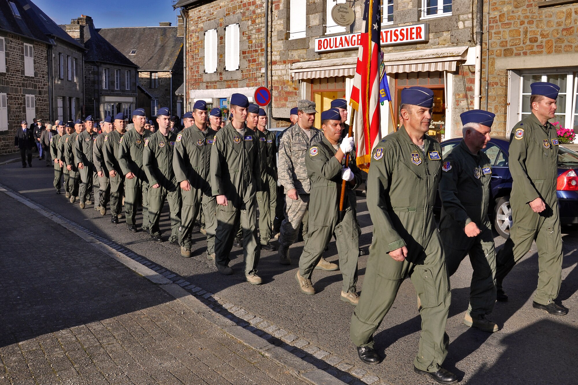 Reserve Airmen from the 514th Air Mobility Wing march through the streets of Lonlay L'Abbaye, France, Sept. 23, 2011. The Airmen were in France to repatriate the wreckage of a bomber that crashed in World War II. The B-17 Flying Fortress spent more than half a century in a French farmers barn before being turned over to the Airmen. The townspeople of Lonlay L'Abbaye, led by their mayor, honored the Airmen with a formal ceremony and reception in the center of town. The 514th Air Mobility Wing is stationed at Joint Base McGuire-Dix-Lakehurst, N.J. (Photo by Tech. Sgt. Shawn J. Jones)