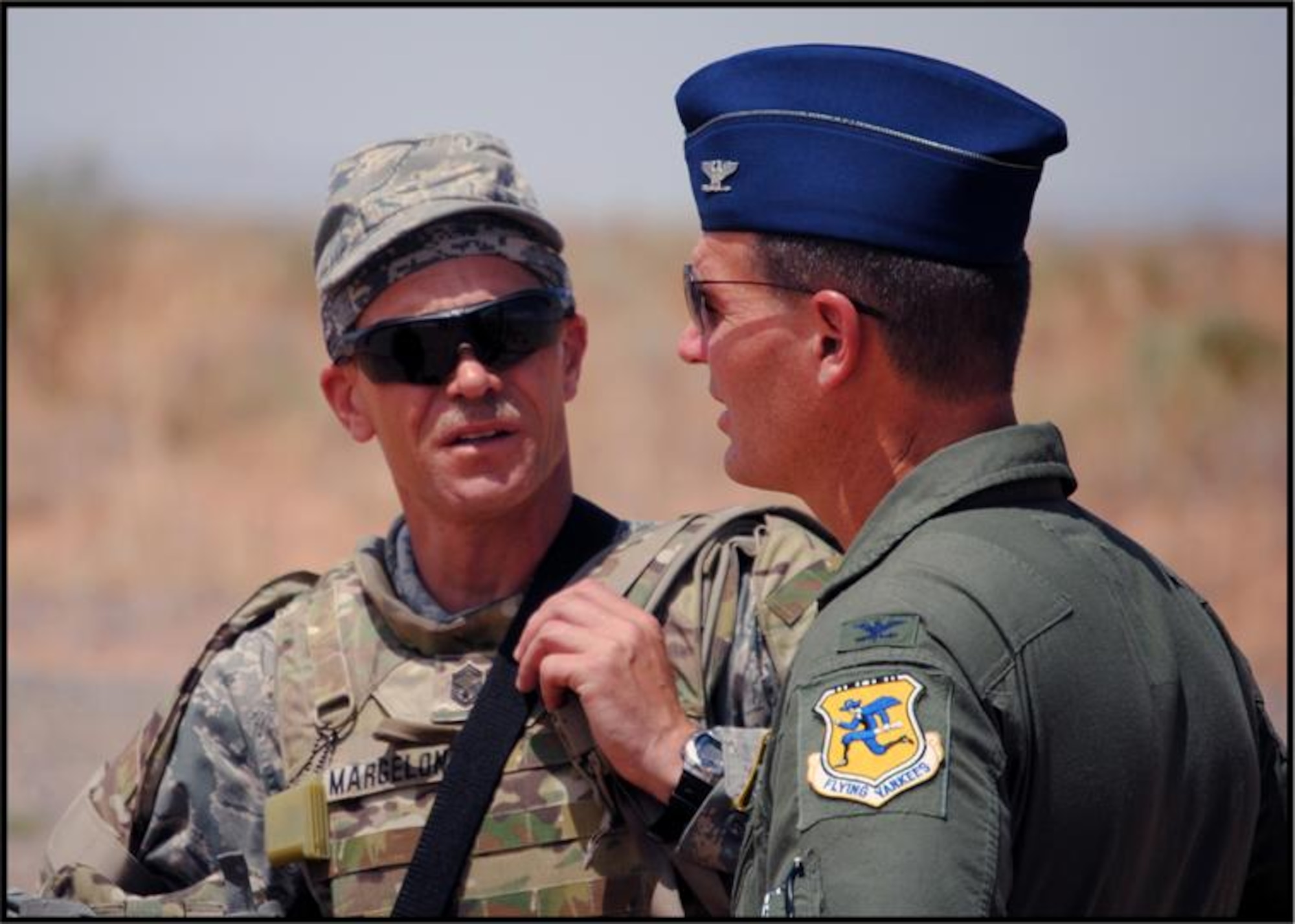 Senior Master Sgt. Douglas Margelony, 103rd Civil Engineer Squadron, relays the day’s training events at Camp McGregor, New Mexico, Aug. 8, 2011, to  Col. Frank Detorie, commander, 103rd Airlift Wing, Connecticut Air National Guard. The Guardsmen were there for Combat Skills Training prior to deploying overseas to work with the 877th Expeditionary Prime BEEF Squadron (Photo by Lt. Col. Roy V. Walton)