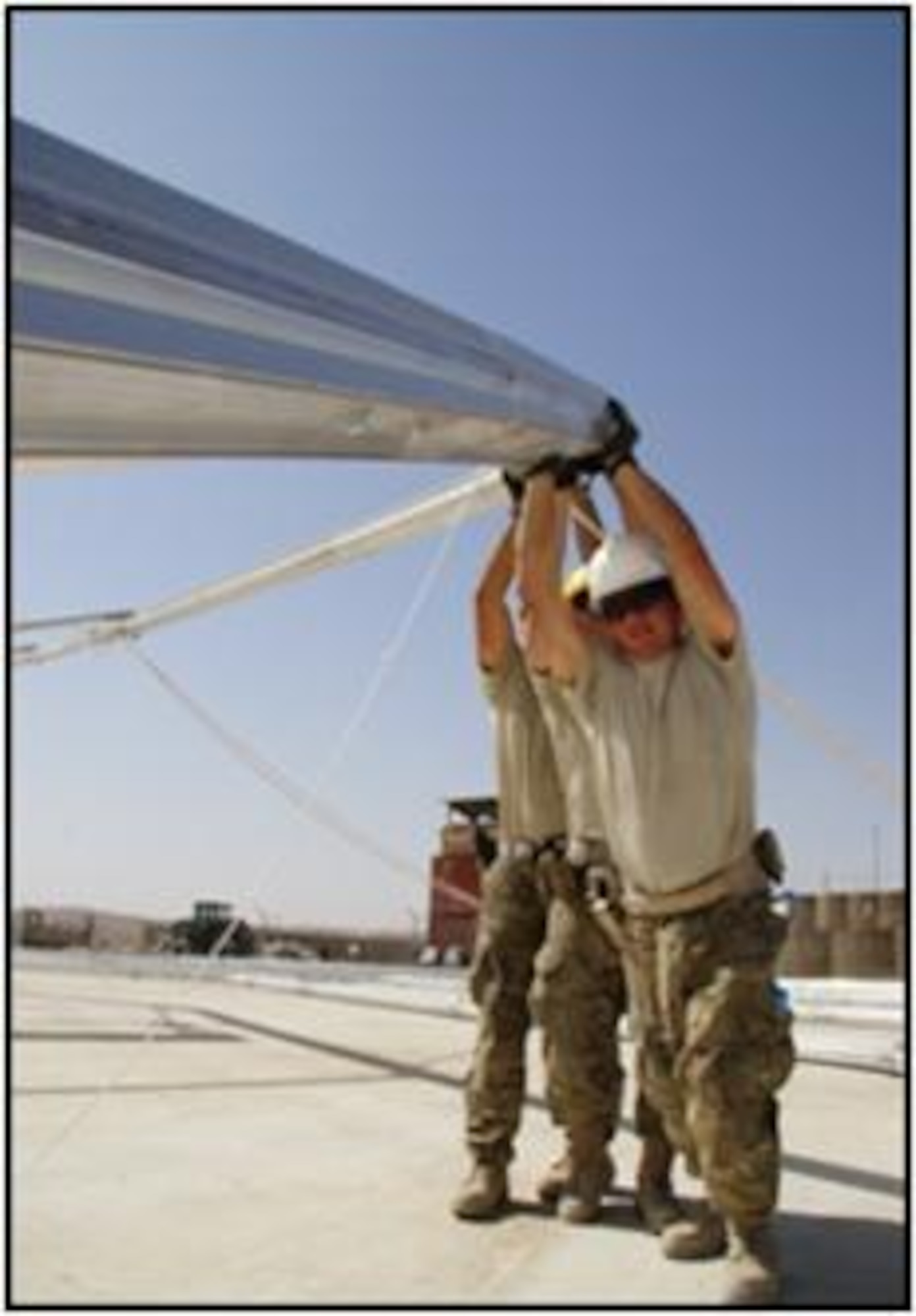 Connecticut Air National Guardsmen position a beam while erecting a Large Aircraft Maintenance Shelter (LAMS) at forward operating base Meymaneh, Afghanistan, last month. Members of the 103rd Civil Engineer Squadron, Connecticut Air National Guard, have  been deployed since July 2011 to the 877th Expeditionary Prime BEEF Squadron. (Photo courtesy of Lt. Col. James Works)