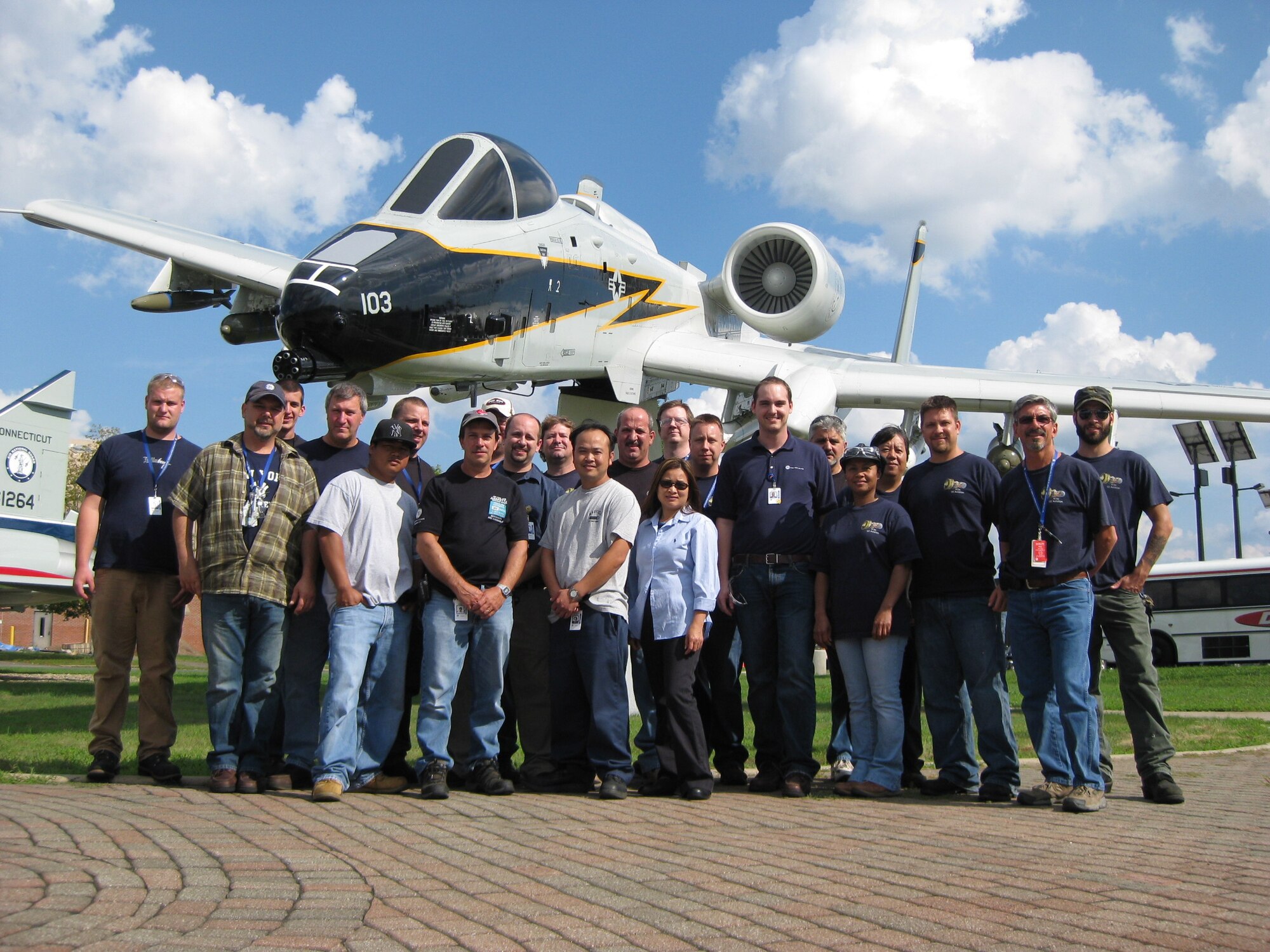 Personnel from Unison Engine Components in Manchester, Conn. pose for a group photo Aug. 10, 2011 in the Air Park at Bradley Air National Guard Base, East Granby, Conn. The group visited the 103rd Airlift Wing's Centralized Repair Facility to get a first-hand look at their product being assembled and installed into the TF34 engine. (U.S. Air Force photo by Staff Sgt. Steven Sevigny)