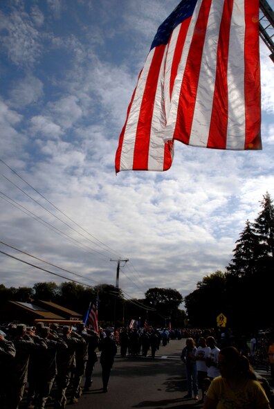 Spectators watch as members of the Enfield Fire Department and the Connecticut Air National Guard's 103rd Airlift Wing pass by as part of a parade held by the fire department commemorating the 10th anniversary of the terrorist attacks of 9/11, in Enfield, Conn., Sept. 11, 2011. The Enfield Fire Department has held this event since 2006, and the 103rd Airlift Wing has been a participant since 2008. (U.S. Air Force photo by Tech. Sgt. Tedd Andrews)