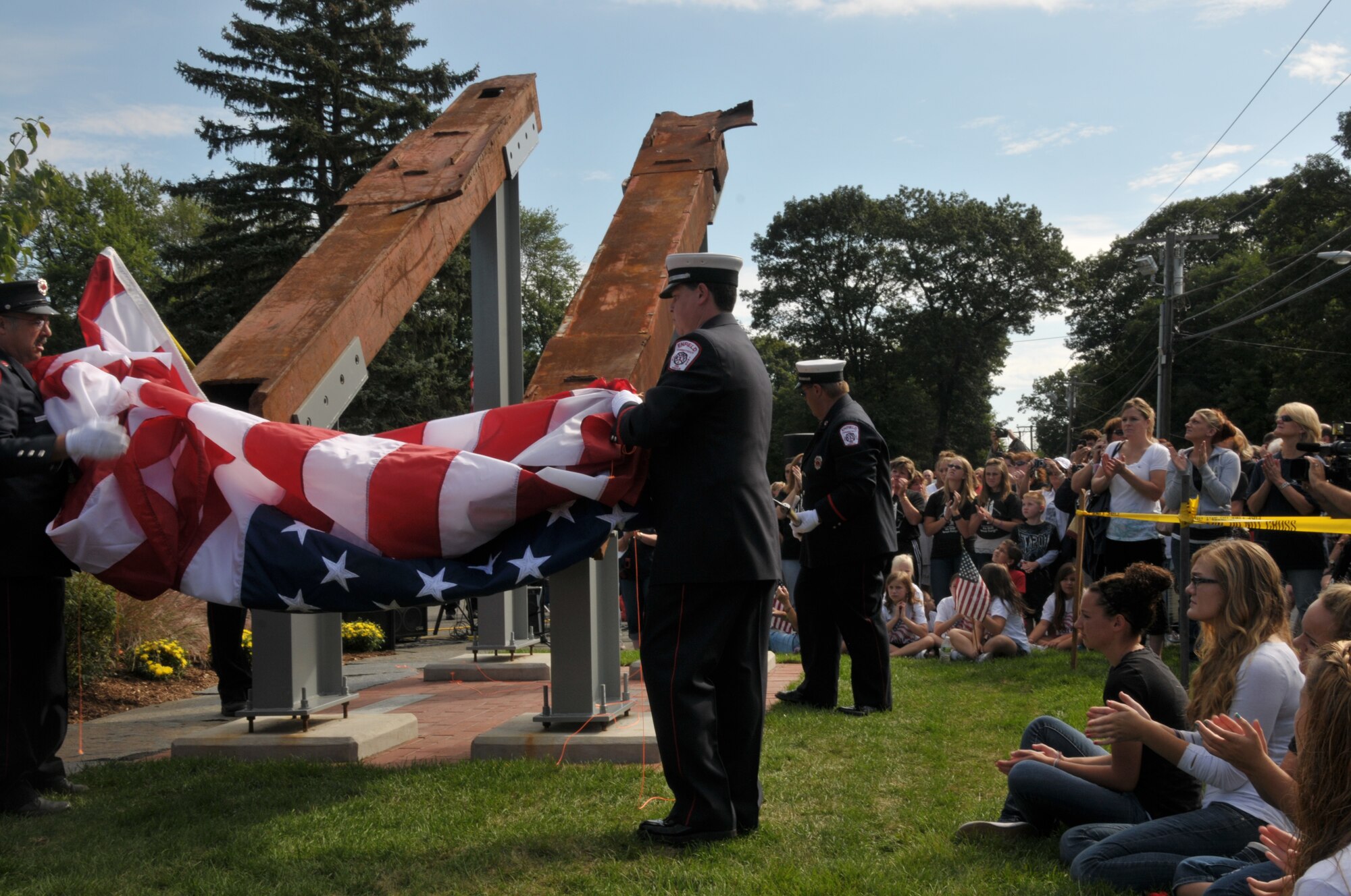 Spectators watch as members of the Enfield Fire Department unveil two pieces of twisted steel salvaged from Ground Zero, during a ceremony commemorating the 10th anniversary of the terrorist attacks of 9/11, in Enfield, Conn., Sept. 11, 2011. The Enfield Fire Department has held this memorial event since 2006. (U.S. Air Force photo by Airman 1st Class Emmanuel Santiago)