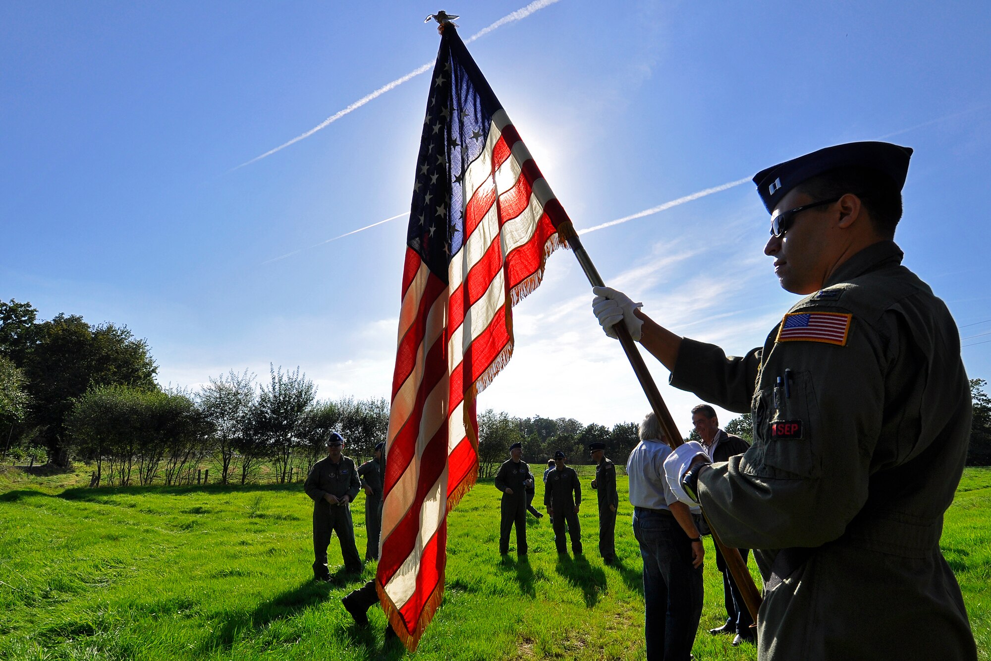 Capt. David Rodriguez, 732nd Airlift Squadron pilot, holds a U.S. flag during a ceremony at the crash site of a World War II-era B-17 Flying Fortress in Lonlay L'Abbaye, France, Sept. 23, 2011. Captain Rodriquez was part of a contingent of Reserve Airmen from the 514th Air Mobility Wing who repatriated the wreckage of the aircraft after it had spent more than half a century in a French farmers barn. The 514th Air Mobility Wing is stationed at Joint Base McGuire-Dix-Lakehurst, N.J. (U.S. Air Force photo/Tech. Sgt. Shawn J. Jones)