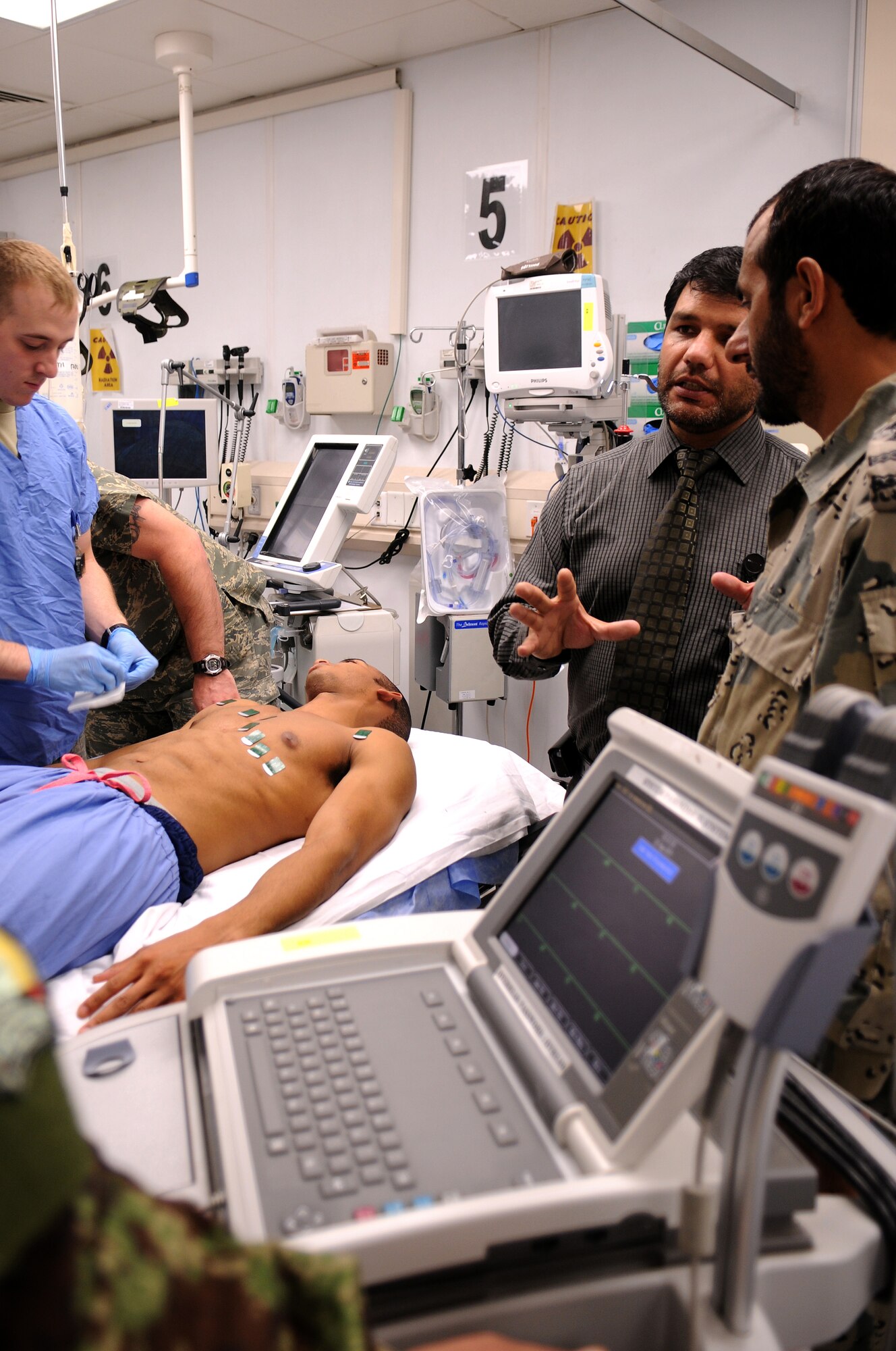 BAGRAM AIRFIELD, Afghanistan -- Senior Airman Kevin Williams 455th Expeditionary Medical Group emergency medical technician, demonstrates electrocardiogram placement on Senior Airman Kevin Williams, 455 EMDG emergency medical technician, as part of the Afghan Trauma Mentorship Program at Craig Joint Theatre Hospital here, Sept. 22, 2011. The ATMP is a joint effort between coalition partners and Airmen from the 455 EMDG designed to familiarize Afghan medical professionals with modern medical procedures and equipment. (U.S. Air Force photo/Senior Airman Krista Rose)  