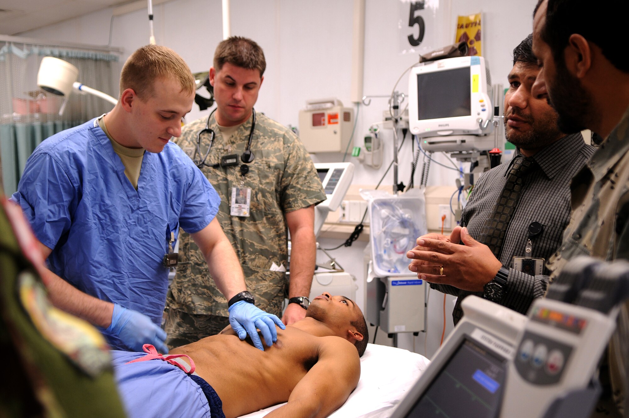BAGRAM AIRFIELD, Afghanistan -- Senior Airman Kevin Williams 455th Expeditionary Medical Group emergency medical technician, demonstrates electrocardiogram placement on Senior Airman Kevin Williams, 455 EMDG emergency medical technician, as part of the Afghan Trauma Mentorship Program at Craig Joint Theatre Hospital here, Sept. 22, 2011. The ATMP is a joint effort between coalition partners and Airmen from the 455 EMDG designed to familiarize Afghan medical professionals with modern medical procedures and equipment. (U.S. Air Force photo/Senior Airman Krista Rose)  
