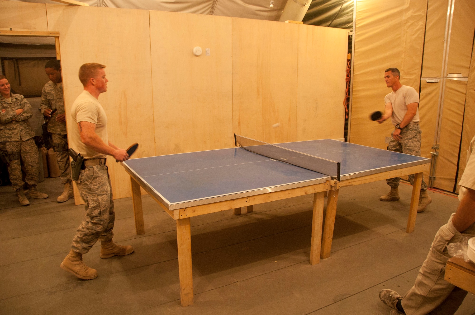 Chief Master Sgt. Richard Parsons, AFCENT command chief, plays ping pong with Senior Airman Shane Appleton, 451st Civil Engineer Squadron force protection augmentee, at Kandahar Airfield, Afghanistan, Sept. 24, 2011. Chief Parsons visited the 451st Civil Engineer Squadron during his trip to Kandahar to speak and address the concerns of deployed Airmen. (U.S. Air Force photo by Senior Airman Corey Hook)