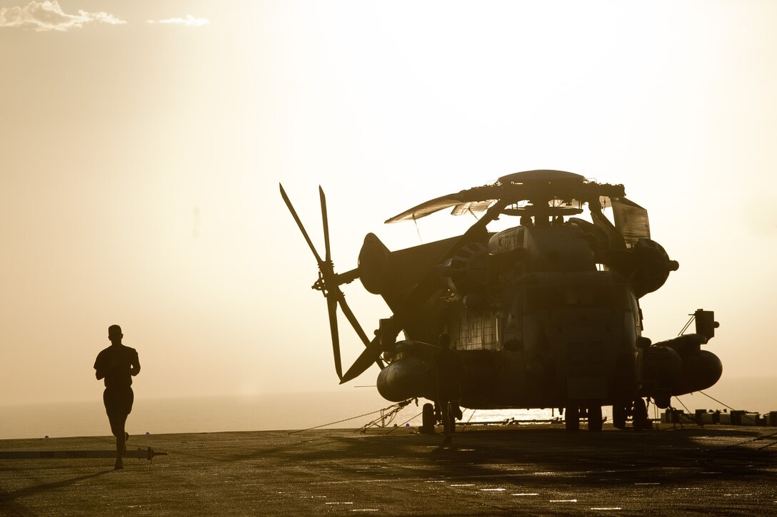 A Marine with the 11th Marine Expeditionary Unit runs on the flight deck here Oct. 1. Marines and sailors embarked the amphibious assault ship Makin Island, the amphibious transport dock New Orleans and the dock landing ship Pearl Harbor in San Diego Sept. 28. The unit is participating in its final exercise before deploying in November.