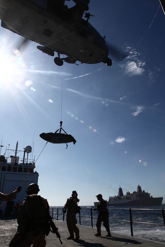 Marines with the 11th Marine Expeditionary Unit's maritime raid force watch as a simulated casualty is lifted into a UH-60 Sea Hawk here Oct. 1. The raid force boarded the cargo vessel ATLS to retake it from simulated pirates and return it to its owners during the MEU’s final two-week exercise before deploying in November.