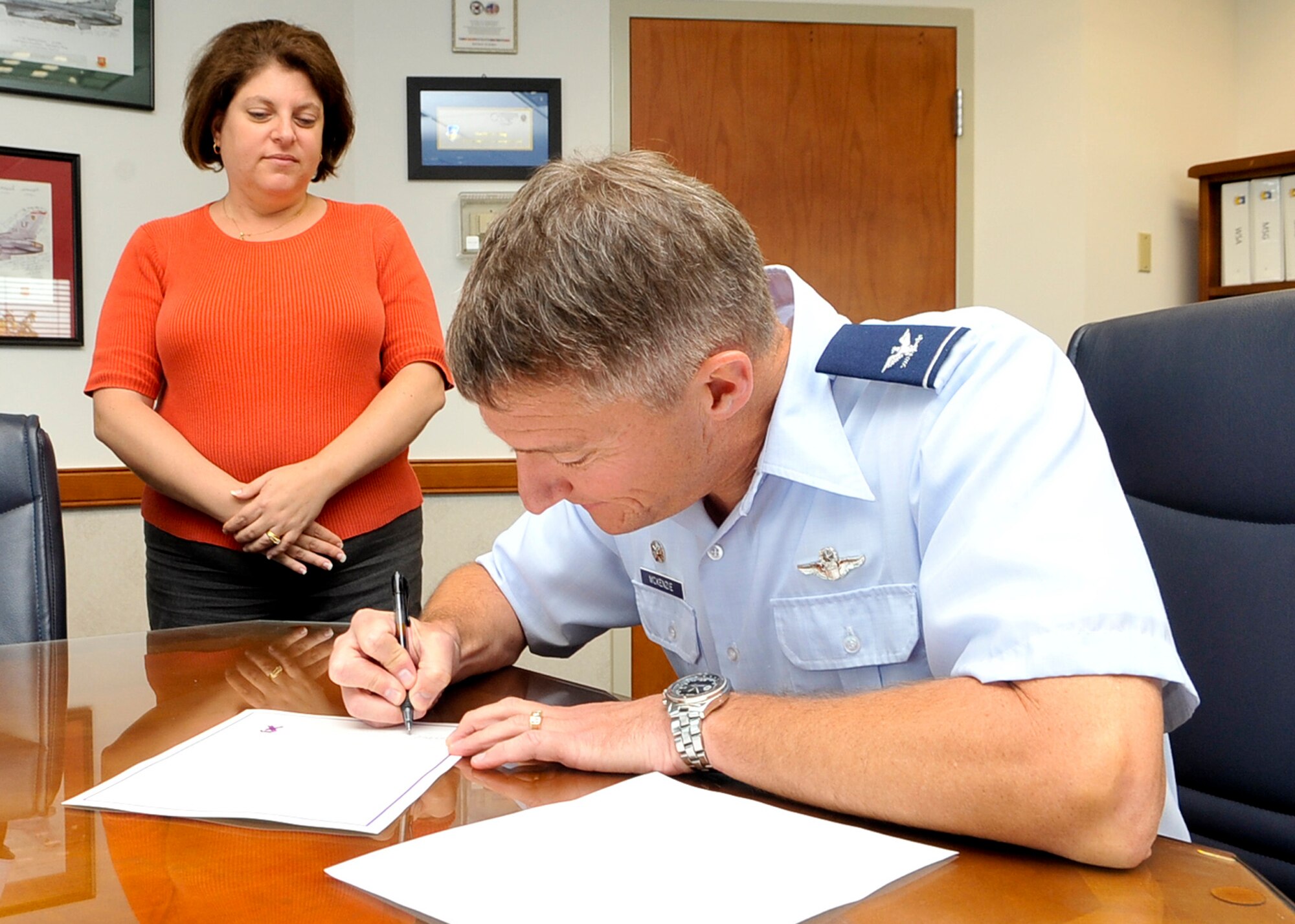 Col. Patrick McKenzie, 51st Fighter Wing commander, signs the Domestic Violence Awareness Month proclamation at Osan Air Base, Republic of Korea, Sept. 26. (U.S. Air Force photo/Senior Airman Adam Grant)