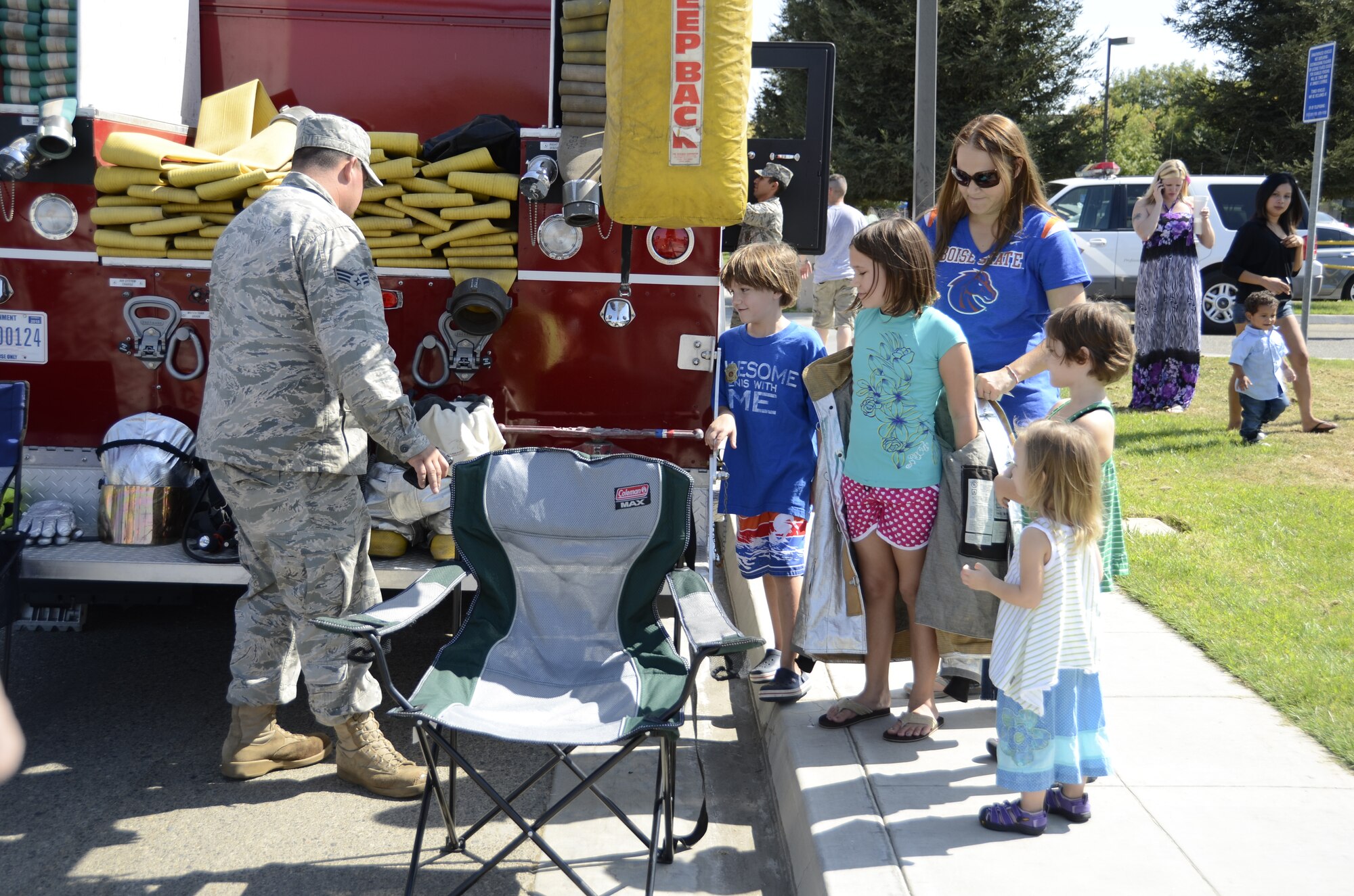 SrA Andrew Adams, a member of the 144th Fighter Wing Fire Department, showcases the fire engine to the Hood Family during the Oct 2, 2011 Family Day at the Air National Guard Base, Fresno Calif. The Family Day introduces military family members to Air Guard day to day operations and work environments along with games, food, and entertainment. (U.S. Air Force photo by Tech Sgt Robin Meredith)