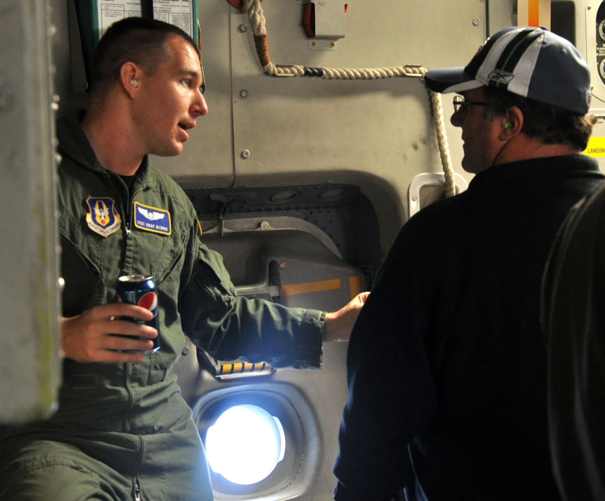 Staff Sgt. Shay Dennis, a loadmaster with the 728th Airlift Squadron, shares some of his knowledge with a civilian employer during an orientation flight aboard a C-17 Globemaster III aircraft assigned to the 446th Airlift Wing on Oct. 1, 2011. The  demonstration flight was part of the wing's Employer Orientation Day, a biannual event designed to foster a strong relationship between civilian employers and the Air Force Reserve. (U.S. Air Force photo/Staff Sgt. Grant Saylor) 