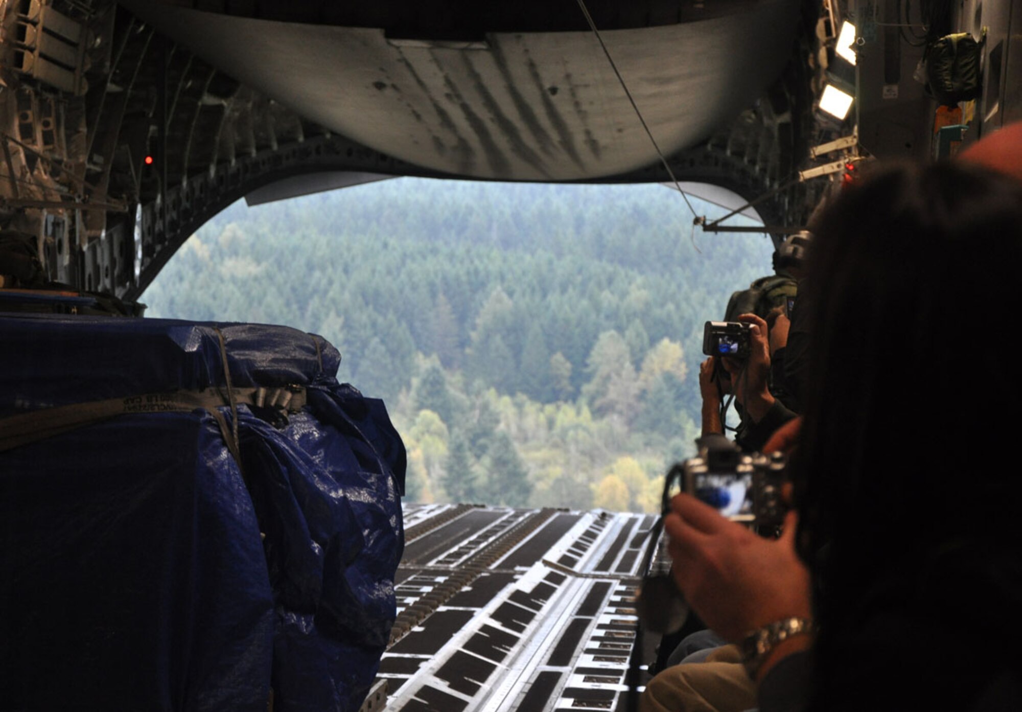 Civilian employers ready their cameras as a C-17 Globemaster III aircraft assigned to the 446th Airlift Wing prepares to airdrop a palletized cargo pod over a drop zone near Joint Base Lewis-McChord, Wash. on Oct. 1, 2011. The demonstration was part of the wing's Employer Orientation Day, a biannual event designed to foster a strong relationship between civilian employers and the Air Force Reserve. (U.S. Air Force photo/Staff Sgt. Grant Saylor) 