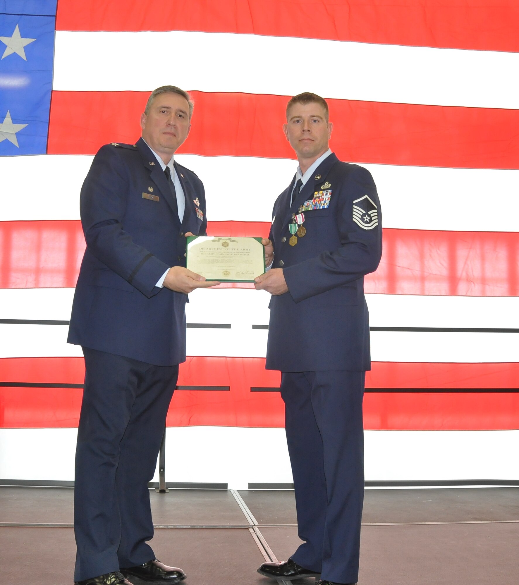 U.S. Air Force Master Sgt. Cory DeMuth (right) receives the Defense Meritorious Service Medal and Army Commendation Medal from Col. Darrell Young, 934th Airlift Wing Commander, Oct. 2 for his life saving efforts in Iraq. (Air Force photo/TSgt. Bob Sommer)