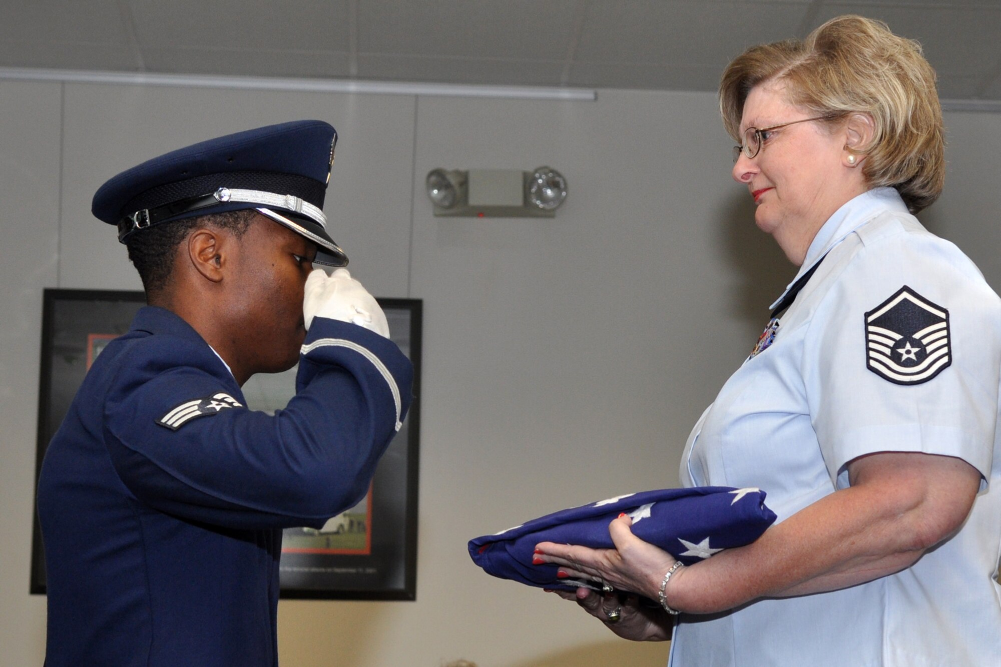 A member of the Barksdale Air Force Base Honor Guard presents an American Flag to retired Master Sgt. Naomi Soliday, during her retirement ceremony at the 307th Bomb Wing headquarters building, Oct. 1, 2011. Soliday was a member of the 307th Civil Engineer Squadron. The presiding officer for the ceremony was Maj. Michael J. Gibbons, who is a B-52 flight test evaluator radar navigator, assigned to the 10th Flight Test Squadron, Tinker Air Force Base, Okla. (U.S. Air Force photo by Master Sgt. Jeff Walston/Released) 