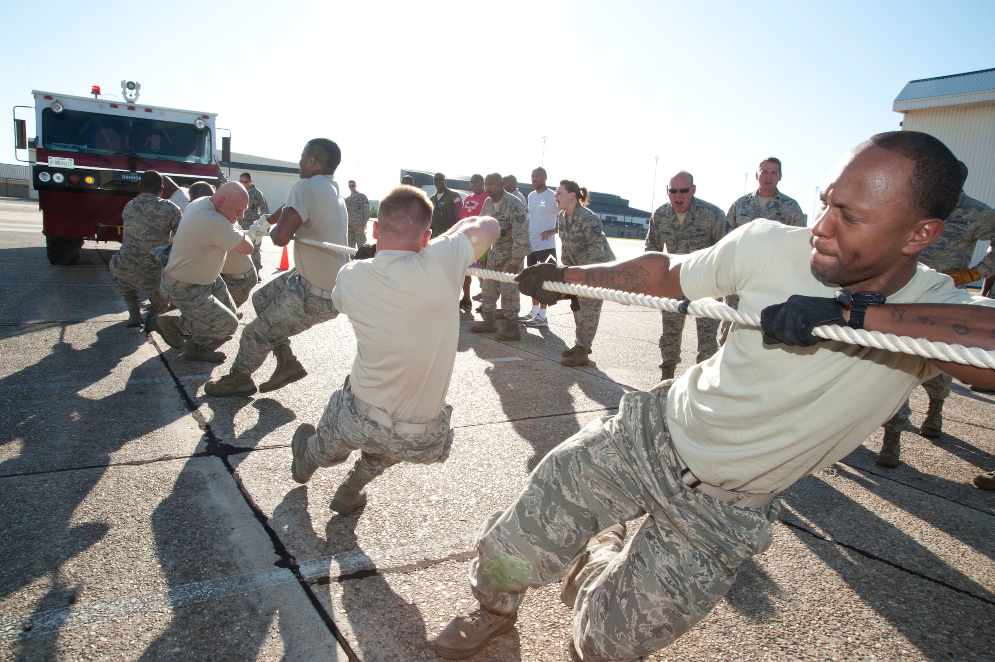 Staff Sgt. Brandon Martin (right), 403rd Civil Engineers Squadron firefighter, digs in his heels as he and his teammates pull a P19 aircraft rescue firefighting truck 50 feet during the 403rd Wing fire truck pull. Six teams of 16 wing members competed in hauling the 32,000-pound truck during the Oct. 1 event. The goal was to “go the distance” in the shortest amount of time. The fire truck pull, sponsored by the 403rd Wing Human Resources Development Council and the Rising VI, was a fun way to highlight the importance of teamwork before the wing’s Operational Readiness Inspection in January 2012. (U.S. Air Force photo/Tech. Sgt. Ryan Labadens)