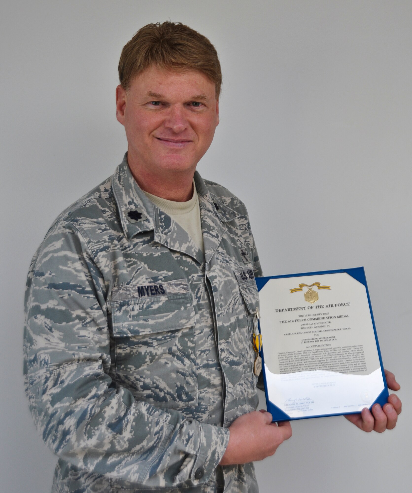 Lt. Col. Christopher Myers, a chaplain with the 128th Air Refueling Wing, presents an Air Force Commendation Medal and accompanying first Oak leaf cluster following the medal's presentation on Saturday, October 1, 2011.  Chaplain Myers received the first Oak leaf cluster for his accomplishments during an overseas deployment in 2010, wherein he was responsible for 15 worship services and an ongoing educational class.  U.S. Air Force photo by Staff Sgt. Jeremy Wilson 