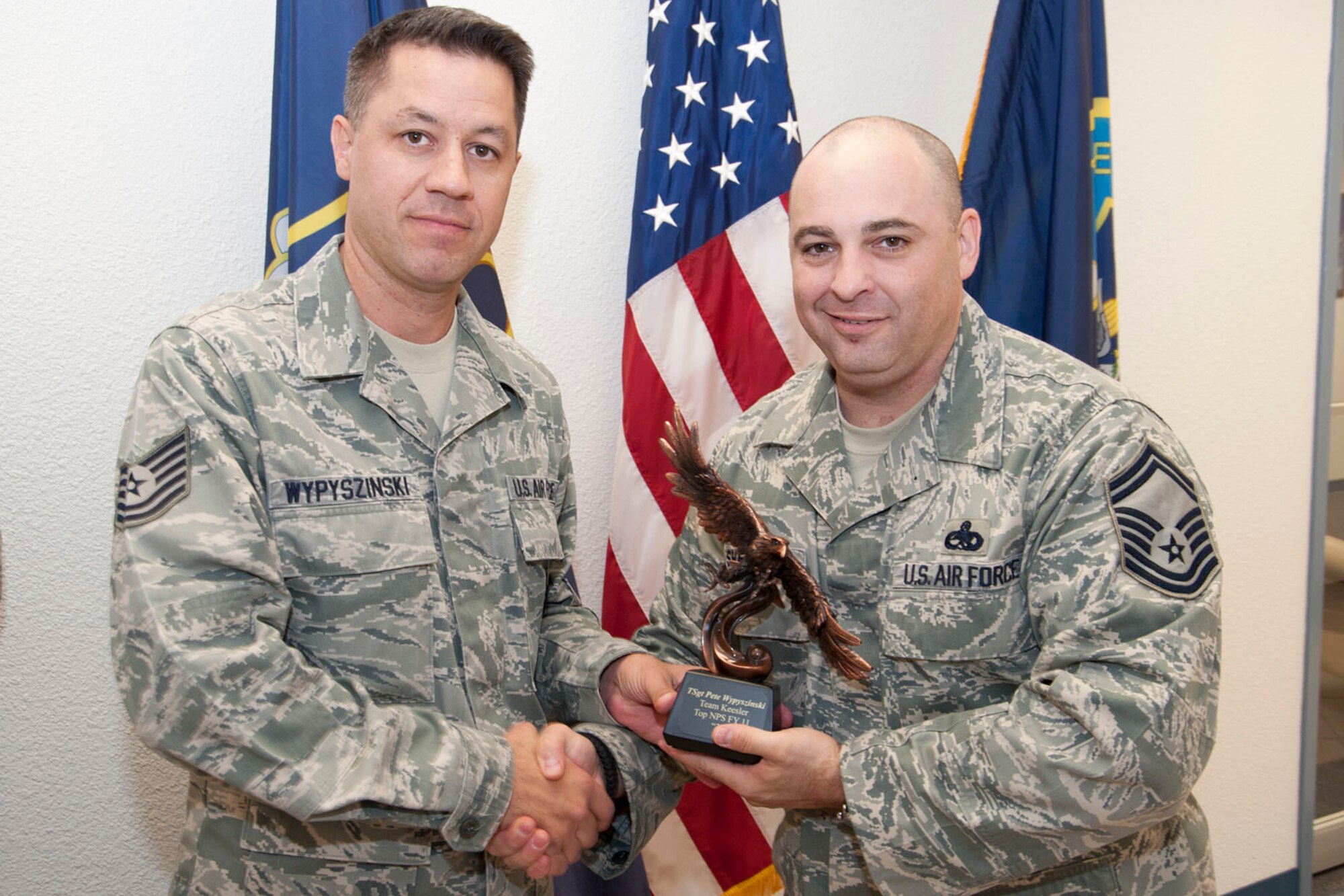Tech. Sgt. Pete Wypyszinski, 403rd Wing recruiter, accepts the Top Non-Prior Service Award Oct. 1 from Senior Master Sgt. Neil Sherman, 403rd Wing senior recruiter. This annual award is presented to the recruiter who enlisted the most non-prior-service members for the fiscal year – 33 in Wypyszinsk’s case. (U.S. Air Force photo/Tech. Sgt. Ryan Labadens)