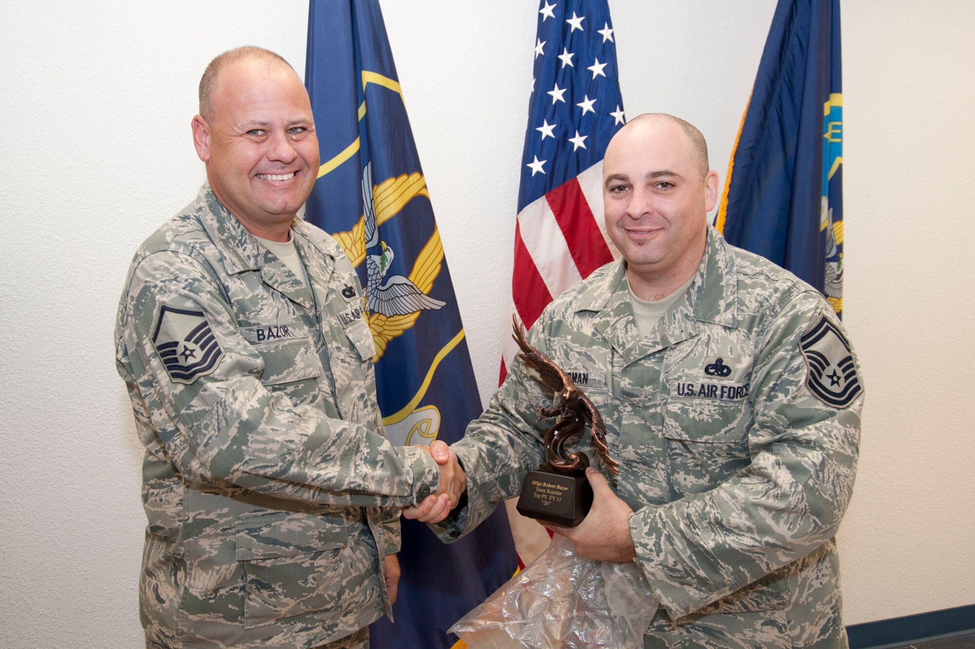 Master Sgt. Robert Bazor, 403rd Wing recruiter, accepts the Top Prior Service Award Oct. 1 from Senior Master Sgt. Neil Sherman, 403rd Wing senior recruiter. This annual award is presented to the recruiter who enlisted the most prior-service members for the fiscal year – 26 in Bazor’s case. Bazor also received the Century Club award. Only the top three percent of Air Force recruiters earn this honor. This is a first for Bazor, and it’s the first time a Keesler Air Force Base recruiter has received this award. (U.S. Air Force photo/Tech. Sgt. Ryan Labadens)