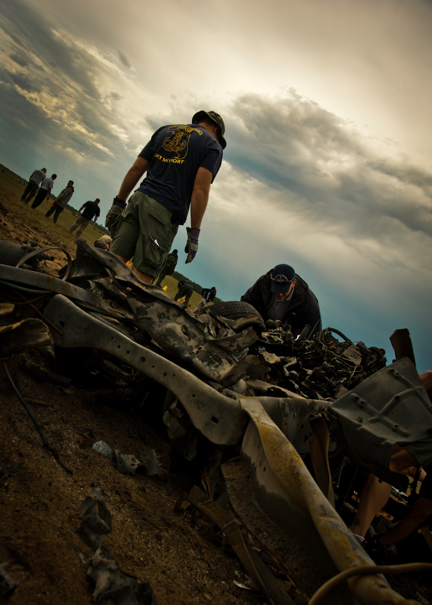 Chief Petty Officer Jack Hanson, of Explosive Ordnance Disposal Mobile Unit 6 from Naval Air Station Mayport, and others scavenge the post-blast scene for evidence and clues as to the cause of the explosion Sept. 28 on the Eglin Air Force Base range.  The investigation was part of the FBI's large vehicle post blast school attended by state and local law enforcement agencies as well as Navy and Air Force explosive ordnance disposal technicians. Three vehicles were blown up to create the crime scenes that students would investigate. The week-long course was the second held on Eglin with 67 students representing 18 different U.S. agencies. (U.S. Air Force photo/ Samuel King Jr.)