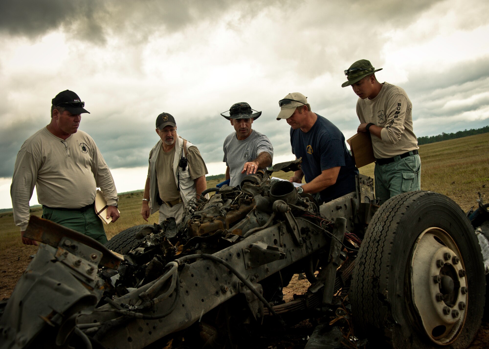 Capt. Thomas Bosco, a Florida State fire marshal, (middle) and other team members size up the blast scene and try to determine where the vehicle’s identification number may be located Sept. 28 on the Eglin Air Force Base range.  The investigation was part of the FBI's large vehicle post blast school attended by state and local law enforcement agencies as well as Navy and Air Force explosive ordnance disposal technicians. Three vehicles were blown up to create the crime scenes that students would investigate. The week-long course was the second held on Eglin with 67 students representing 18 different U.S. agencies. (U.S. Air Force photo/ Samuel King Jr.)
