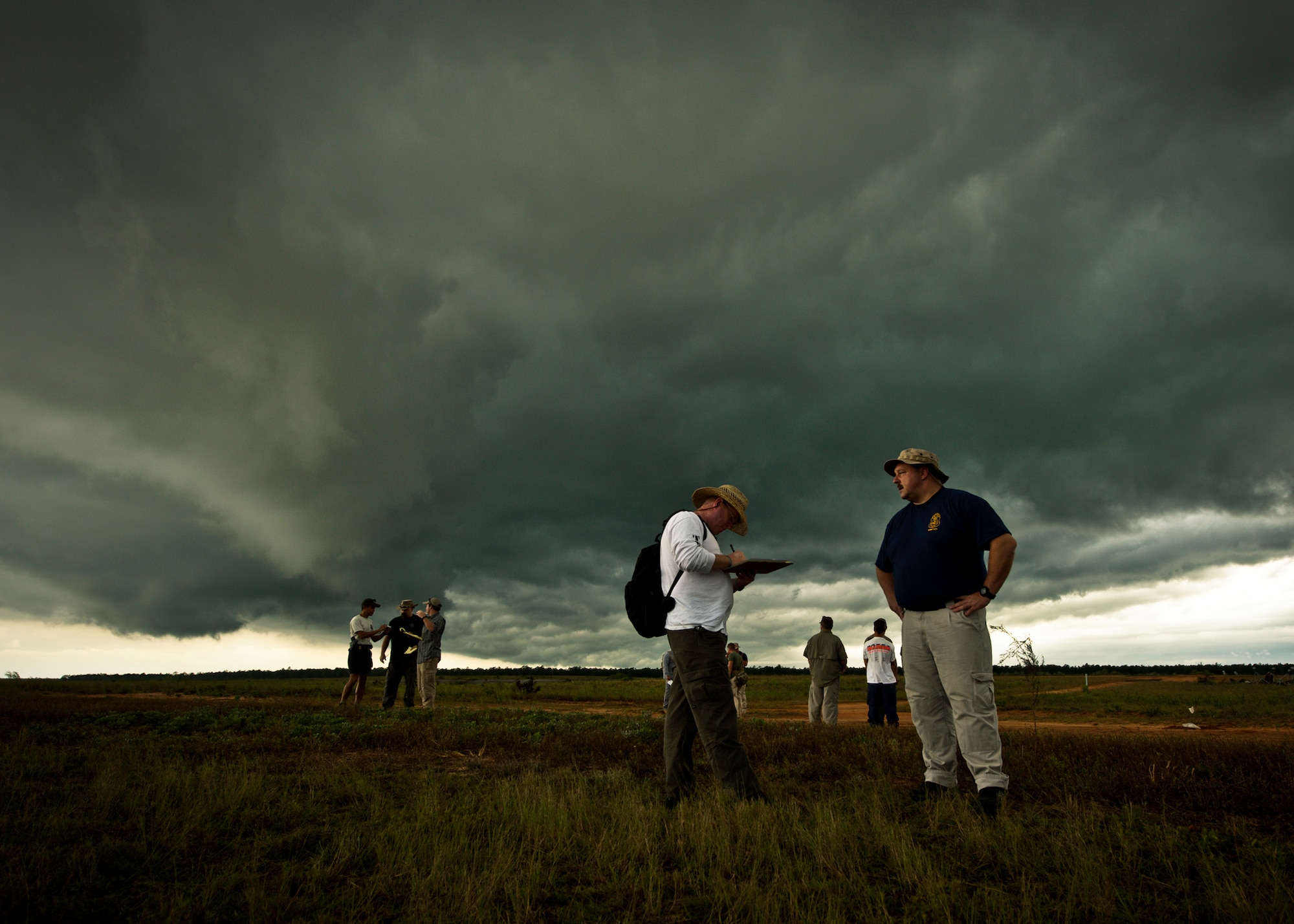 Detective Damon Sullivan, from the Leon County Sheriff’s Office, and others interview the key witnesses at the scene of the blast as a storm cloud rolls across Eglin Air Force Base’s range Sept. 28.  The interviews were part of the FBI's large vehicle post blast school attended by state and local law enforcement agencies as well as Navy and Air Force explosive ordnance disposal technicians. Three vehicles were blown up to create the crime scenes that students would investigate. The week-long course was the second held on Eglin with 67 students representing 18 different U.S. agencies. (U.S. Air Force photo/ Samuel King Jr.)