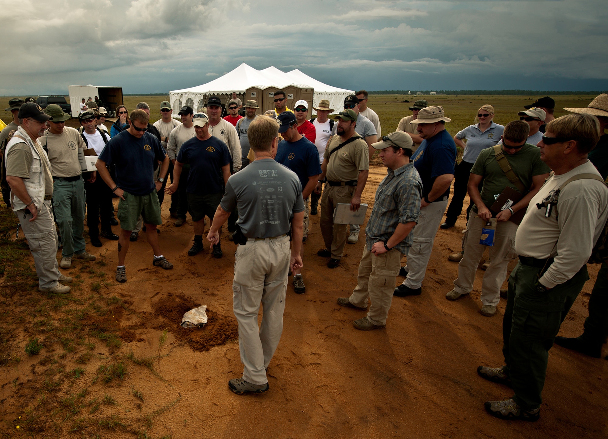 Special Agent Kevin Miles, the FBI post blast school instructor, points out a booby trap at the edge of the road during the first day of the post-blast investigation scenario Sept. 28 on the Eglin Air Force Base range.  The investigations were part of the FBI's large vehicle post blast school attended by state and local law enforcement agencies as well as Navy and Air Force explosive ordnance disposal technicians. Three vehicles were blown up to create the crime scenes that students would investigate. The week-long course was the second held on Eglin with 67 students representing 18 different U.S. agencies. (U.S. Air Force photo/ Samuel King Jr.)