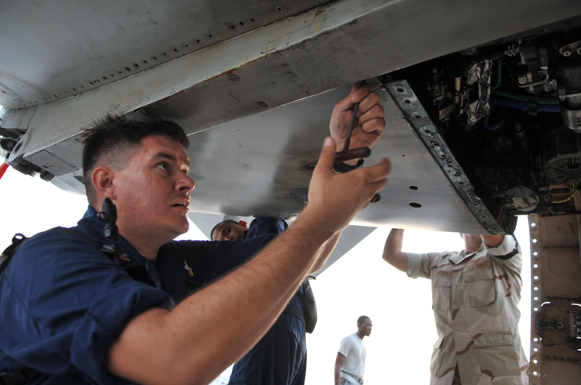 Aviation Machinist’s Mate First Class Jason Chadderton stationed aboard USS John C. Stennis (CVN 74), removes a covering from a Navy F/A-18C Hornet, Sept. 28, 2011, at an undisclosed location in Southwest Asia. Chadderton, a native of Las Vegas, Nev., is assigned to Carrier Air Wing (CVW) 9 embarked aboard Stennis and home based at Naval Air Station Lemoore, Calif. (U.S. Air Force photo/Senior Airman Paul Labbe)