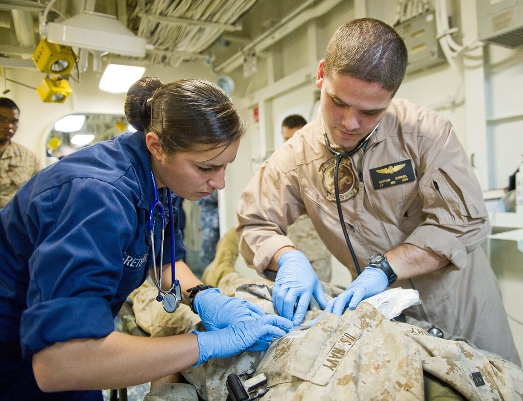 Navy Lt. Nathan Zundel, right, assesses a simulated casualty on the amphibious assault ship Makin Island here Oct. 2 during a casualty evacuation exercise. Zundel, 33, who hails from Farmington, Utah, is the flight surgeon for Marine Medium Helicopter Squadron 268 (Reinforced), the aviation combat element for the 11th Marine Expeditionary Unit. The unit is participating in its final exercise before deploying in November.
