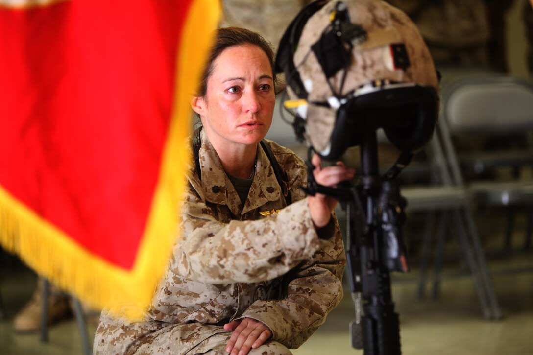 Cmdr. Erica Miller, the flight surgeon for the 2nd Marine Aircraft Wing (Forward), pays her respects during an Oct. 3 memorial service for Capt. Ryan Iannelli, who died supporting combat operations in Afghanistan, Sept. 28. Miller serves as the top medical official for the 2nd Marine Aircraft Wing (Forward), which provides the aviation capability for the southwestern regional command of NATO’s International Security Assistance Force.::r::::n::