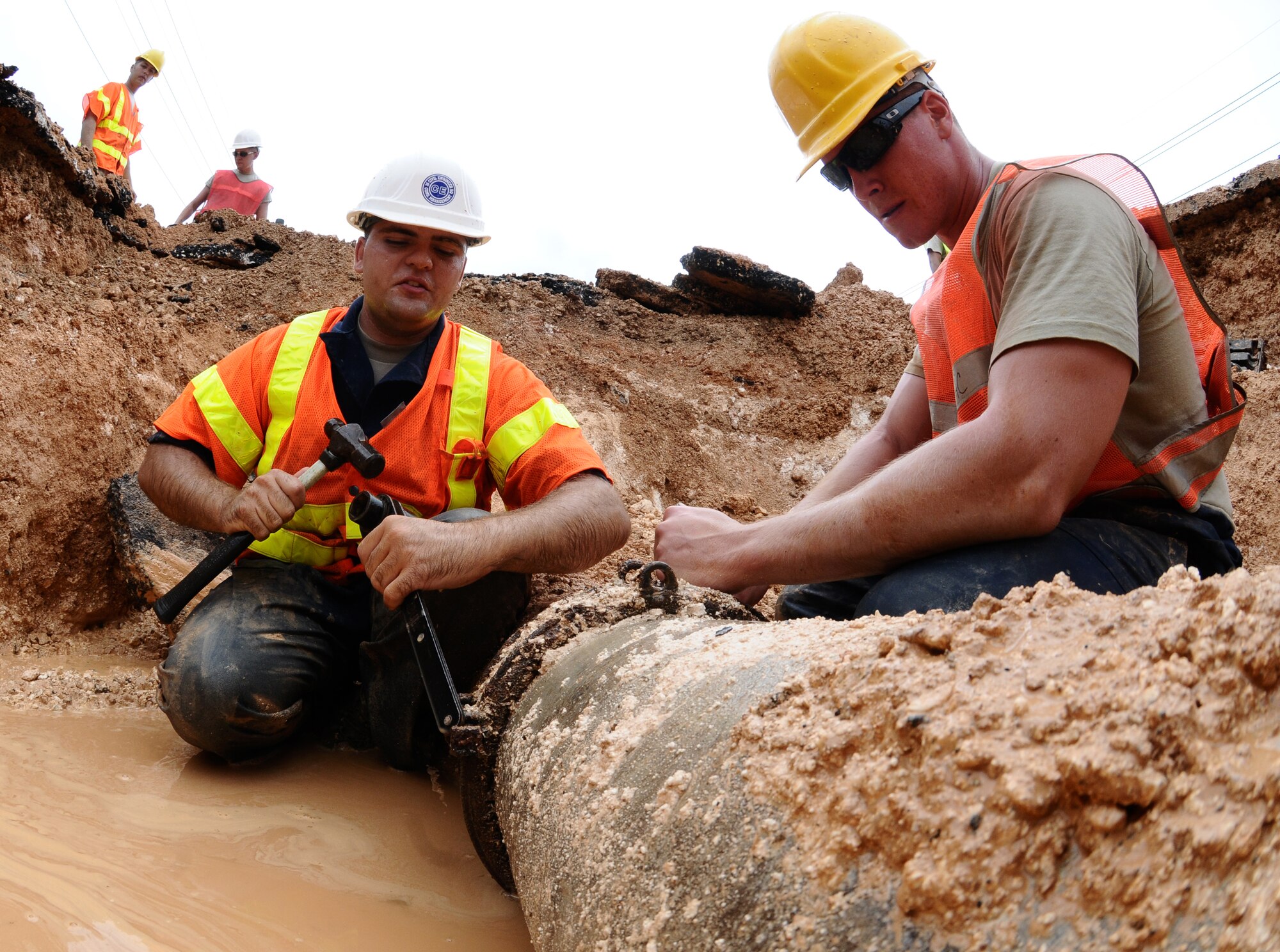 YIGO, Guam—Airmen 1st Class Matthew Cornell and Patrick Heskey, 36th Civil Engineer Squadron, removes a coupling from a busted water pipeline here, Oct. 1. During the repair, members of the 36 CES diverted the water supply around the busted pipe to ensure that Andersen Air Force Base could continue to have water as repairs were made. (U.S. Air Force photo by Senior Airman Benjamin Wiseman/Released)