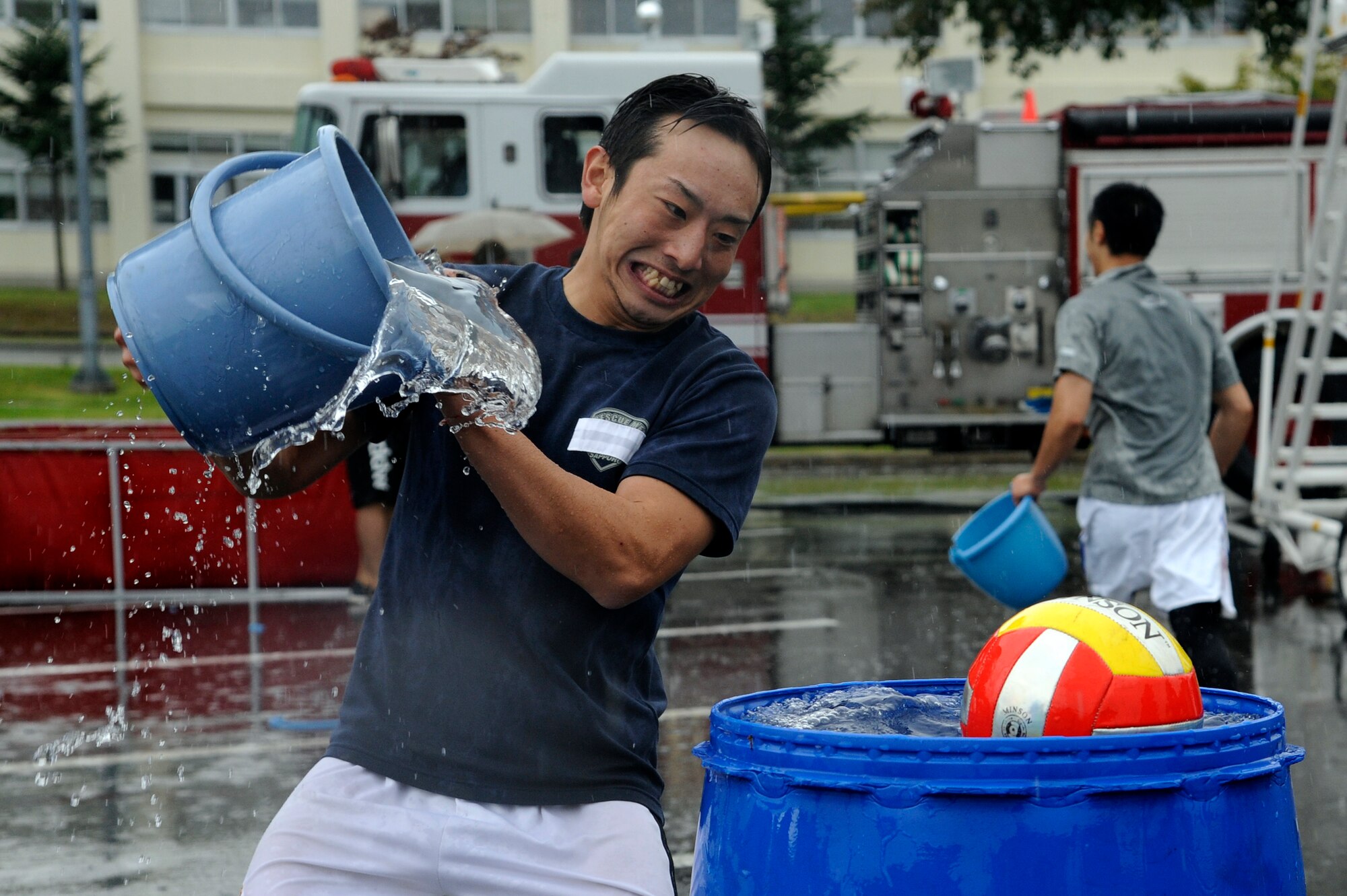 MISAWA AIR BASE, Japan -  A local Japanese firefighter tries to knock the ball out of a bucket during the bucket brigade event part of the fire muster competition held at the base exchange parking lot here Oct. 2.  Firefighters from the 35th Civil Engineer Squadron along with firefighters from Misawa City and Towada City participated in a fire muster to kick off Fire Prevention Week. Fire Prevention Week was established to commemorate the Great Chicago Fire, the tragic 1871 blaze that killed more than 250 people, left 100,000 homeless, destroyed more than 17,400 structures and burned more than 2,000 acres. In 1920, President Woodrow Wilson issued the first National Fire Prevention Day proclamation, and since 1922, Fire Prevention Week has been observed on the Sunday through Saturday period in which October 9 falls. (U.S. Air Force photo/Tech. Sgt. Marie Brown)
