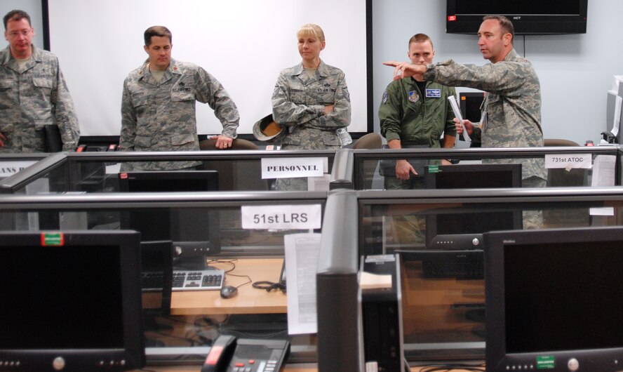 Capt. Charles Russell, 51st Logistics Readiness Squadron installation deployment officer, explains Sept. 27, 2011, how Osan Air Base processes follow-on forces during a 51st Fighter Wing leadership immersion tour through the deployment readiness control center. Listening to the briefing is Chief Master Sgt. Richard Vogel, 51st Medical Group superintendent; Maj. Steven Anderson, 51st Aircraft Maintenance Squadron commander; Master Sgt. Ariane Freeman, 51st Civil Engineer Squadron first sergeant, and Capt. Jeremy Dieringer, 36th Fighter Squadron. Fifty commanders, superintendents and first sergeants toured the four groups of the Osan-based fighter wing.  (Air Force photo by Senior Master Sgt. Stuart Camp)