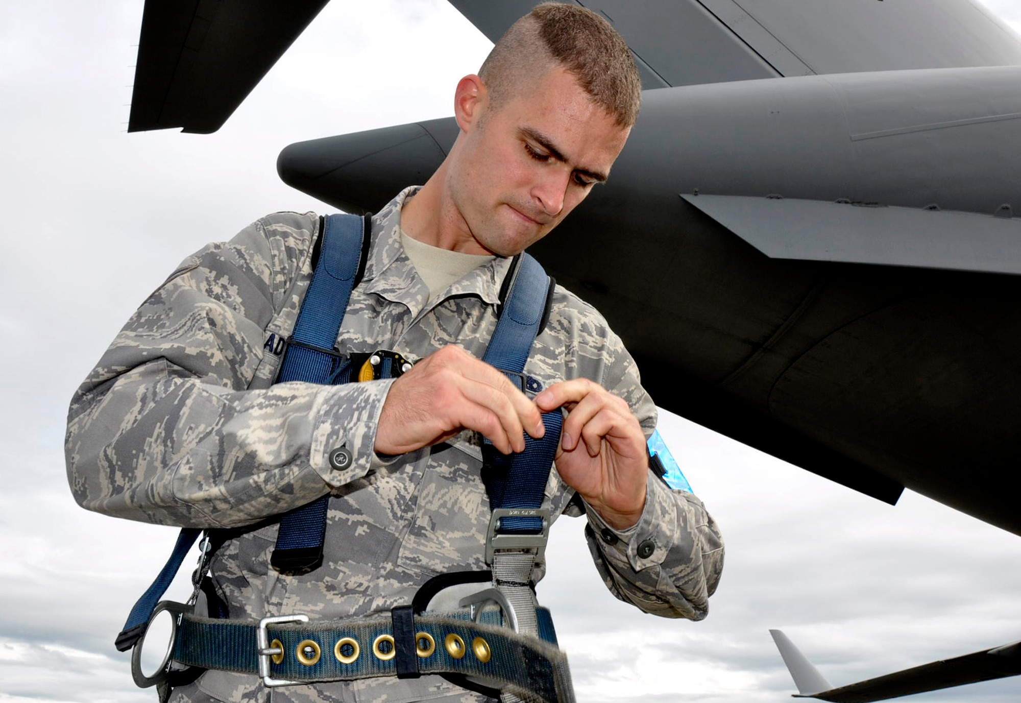Air Force Airman 1st Class Joel Adriance, 446th Aircraft Maintenance Squadron hydaulic systems apprentice out of McChord Field, Wash., makes some last few adjustments to his safety harness before getting in a Condor Maintenance Platform basket to place external locks on a C-17 Globemaster III rudder, Sept. 22, 2011. Adriance is also a high school math teacher in Coupeville, Wash. (U.S. Air Force photo by Master Sgt. Jake Chappelle)