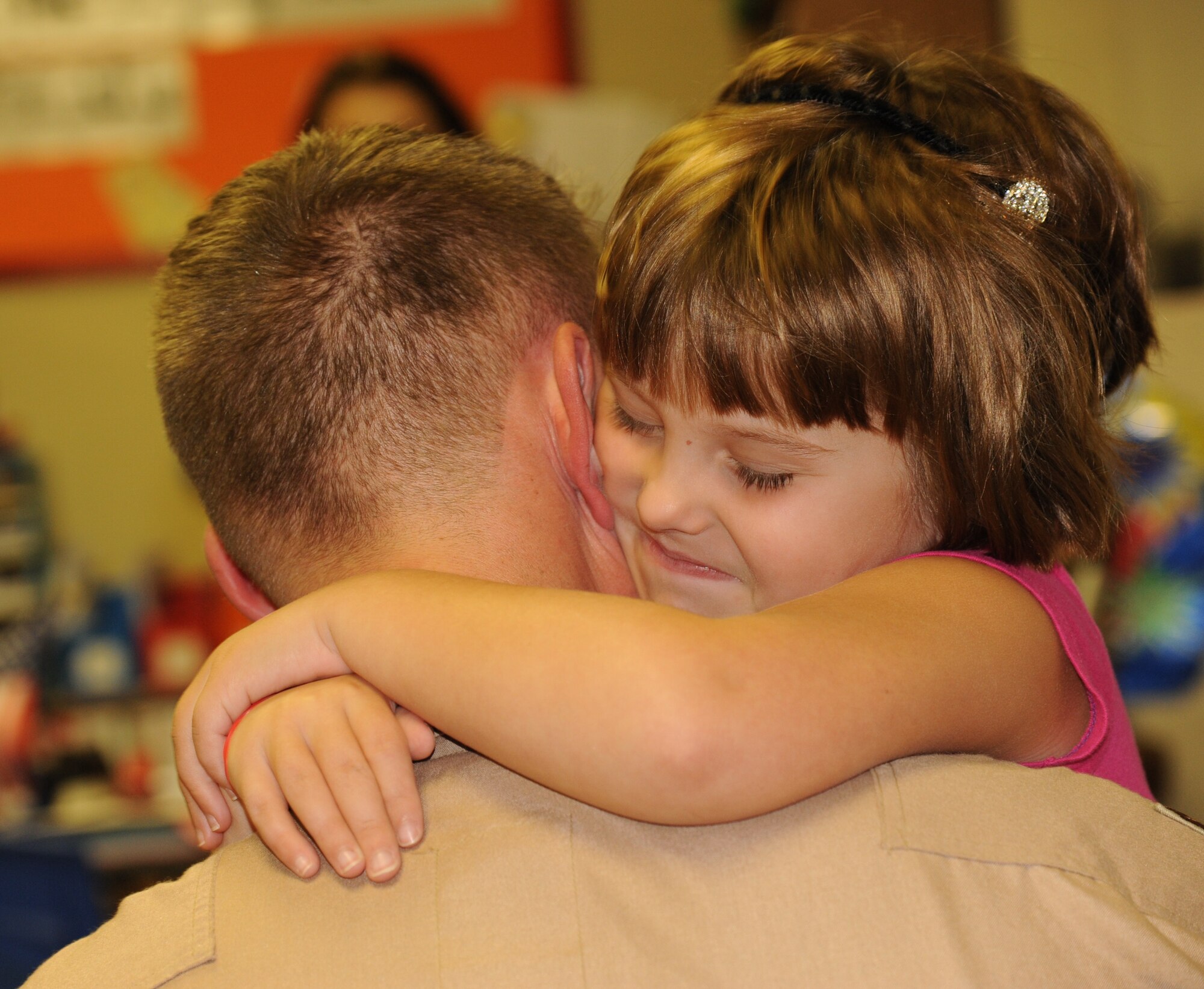 LAUGHLIN AIR FORCE BASE, Texas – Maj. Jonathan Somogyi, 85th Flying Training Squadron instructor pilot, embraces his daughter, Julianna, after surprising her at school Oct. 3. Somogyi returned from a deployment to Manas Air Base, Kyrgyzstan just before arriving at Buena Vista Elementary School in Del Rio. (U.S. Air Force photo/Senior Airman Blake Mize)