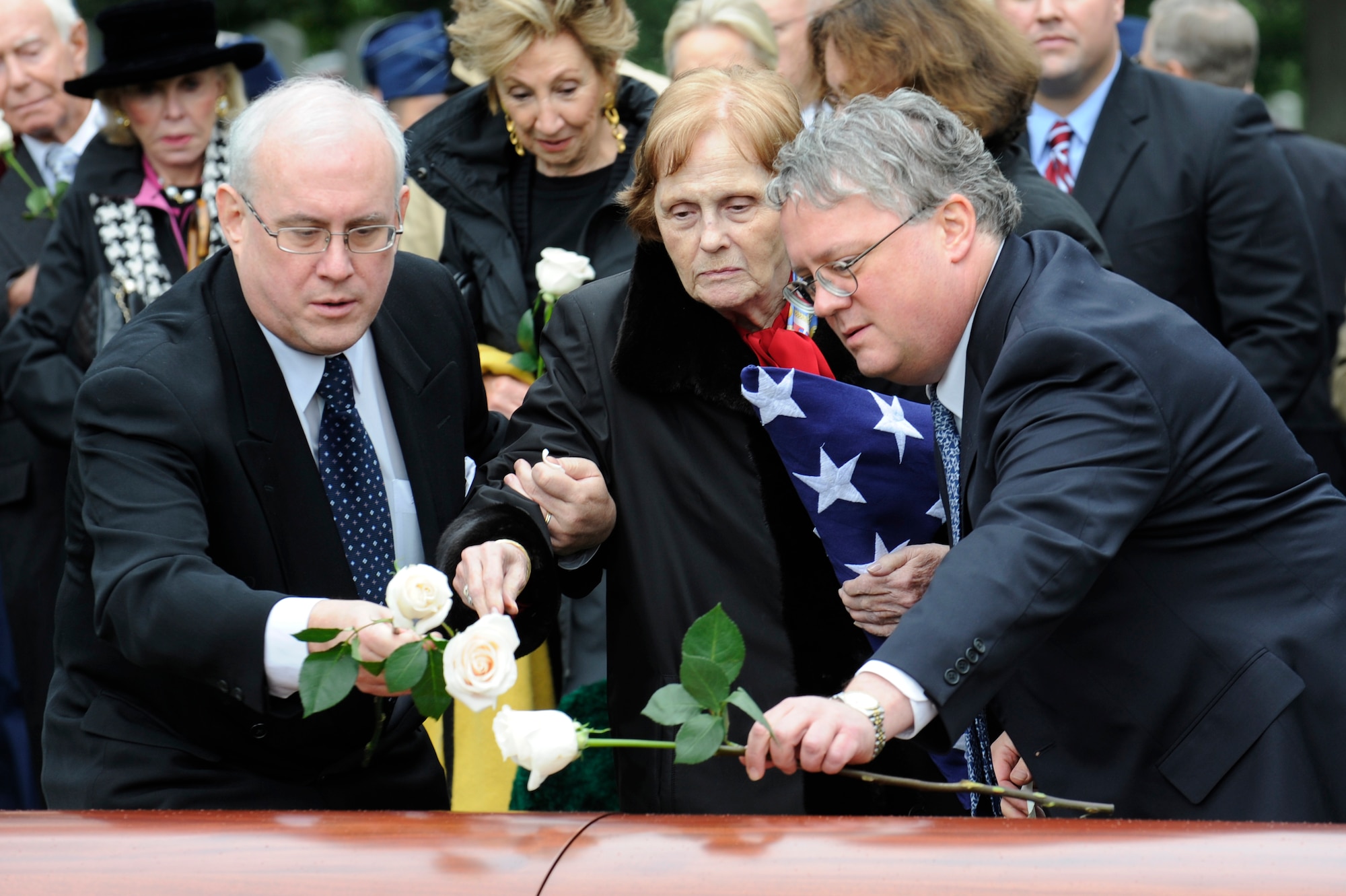 Penni Alison, along with sons John and David, place flowers in honor of their husband and father, retired Maj. Gen. John Alison, during his funeral Oct. 3, 2011. Alison is known for his distinguished Air Force career, during which he flew with the Flying Tigers over the skies of the China-Burma-India theater and helped create the Air Force’s special operations forces.  (U.S. Air Force photo/Tech. Sgt. Raymond Mills)