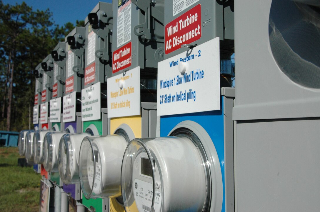 The solar collector panel systems and wind turbines meters are just part of Air Force Special Operations Command?s Project Renewable Energy Demonstration. The combination of the wind turbines and the solar panels are producing 10 times more power than needed and are supplying power to an algae lab and to charge an electrical vehicle. (U.S. Air Force photo by Ashley M. Wright)