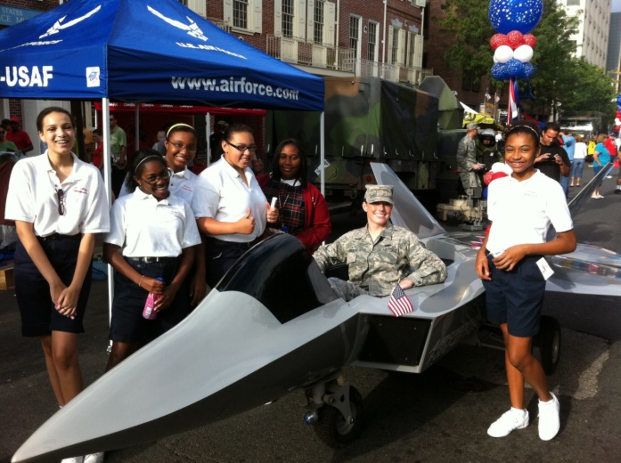 Staff Sgt. Jessica Kosisky, 314th RCS enlisted accession recruiter, (center) sits in an Air Force mini-jet flanked by local high school students during the Fox 29 Salutes the Military appreciation event in Philadelphia, Pa. Sept. 9. Kosisky highlighted the importance of the Explosive Ordinance Disposal career field during an interview with Fox 29. (U.S. Air Force photo/Tech. Sgt. Alfonso Coley)