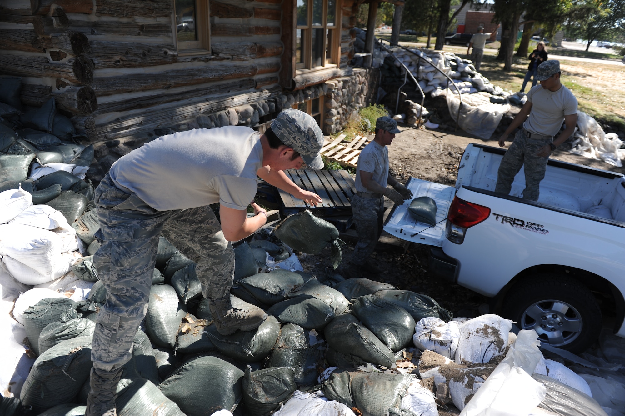 Cadets remove sandbags from a levee around a Girl Scout cabin along the Missouri River. (U.S. Air Force Photo/John Van Winkle)
