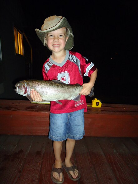 Logan Gates, 4, proudly shows off the fish he caught from Pow Wow park pond Sept 24. He landed the 5 pound, 21 inch rainbow trout with his Batman fishing pole using worms and bobbers. Logan is the son of Tech. Sgt. James Gates, 16th Munitions Squadron ground safety officer. (Courtesy photo)