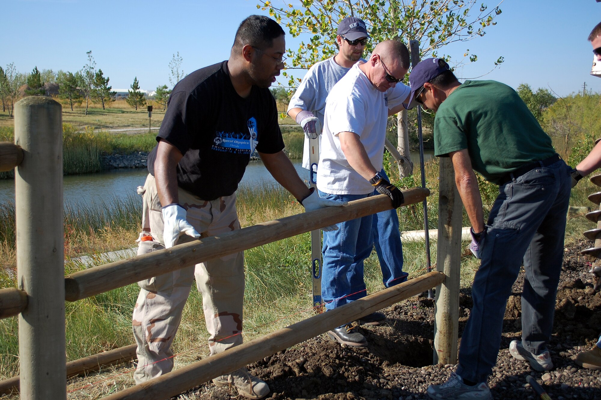 Volunteers help build a split-rail fence at the edge of the parking lot at Pow Wow Park Sept. 24 as one of Malmstrom's projects in support of National Public Lands Day. Pictured from left are Staff Sgt. Duane Bacchus, and Tech. Sgt. Kenneth Ridgeway, 819th RED HORSE Squadron; and Mark Bell and Thomas McManus from Weston Solutions. (U.S. Air Force photo/Valerie Mullett)
