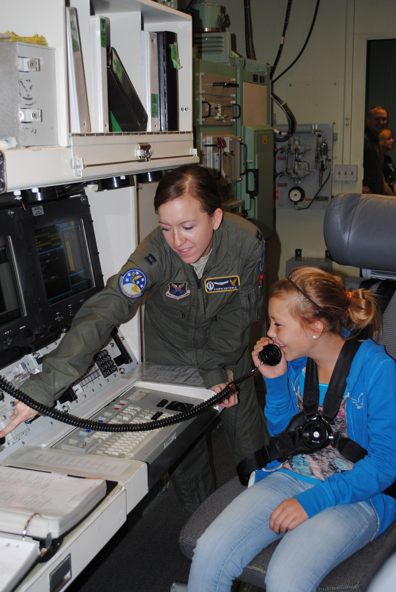 Capt. Stephanie Dieterle, 341st Operations Support Squadron missileer, shows Shyleene, 11, how to operate equipment in the Missile Procedures Trainer.   (U.S. Air Force photo/Airman Cortney Paxton)