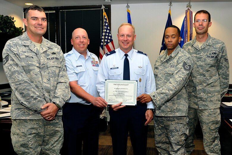 Col. Chris Crawford (center), 21st Space Wing commander, presents the Gold Knight award to the 21st Logistics Readiness Squadron Air Terminal Team. (U.S. Air Force photo/Dennis Howk)