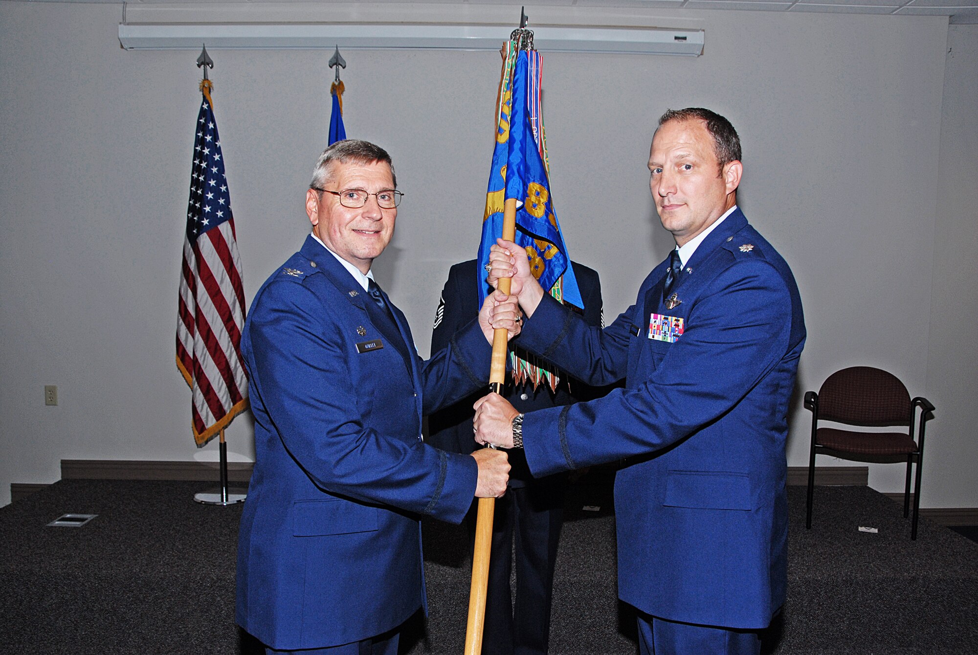 WRIGHT-PATTERSON AIR FORCE BASE, Ohio - Col. Roger Gallet, 445th Operations Group commander, passes the guidon to Lt. Col. Mitchell Richardson, incoming 89th Airlift Squadron commander, during the Sept. 10 change of command ceremony. Richardson assumed command from Col. Michael Bending, who was recently assigned to Scott Air Force Base, Ill. Richardson was assigned to the 317th Airlift Squadron,  Joint Base Charleston, S.C., as an instructor pilot prior to his new position. (U.S. Air Force photo/Tech. Sgt. Anthony Springer)