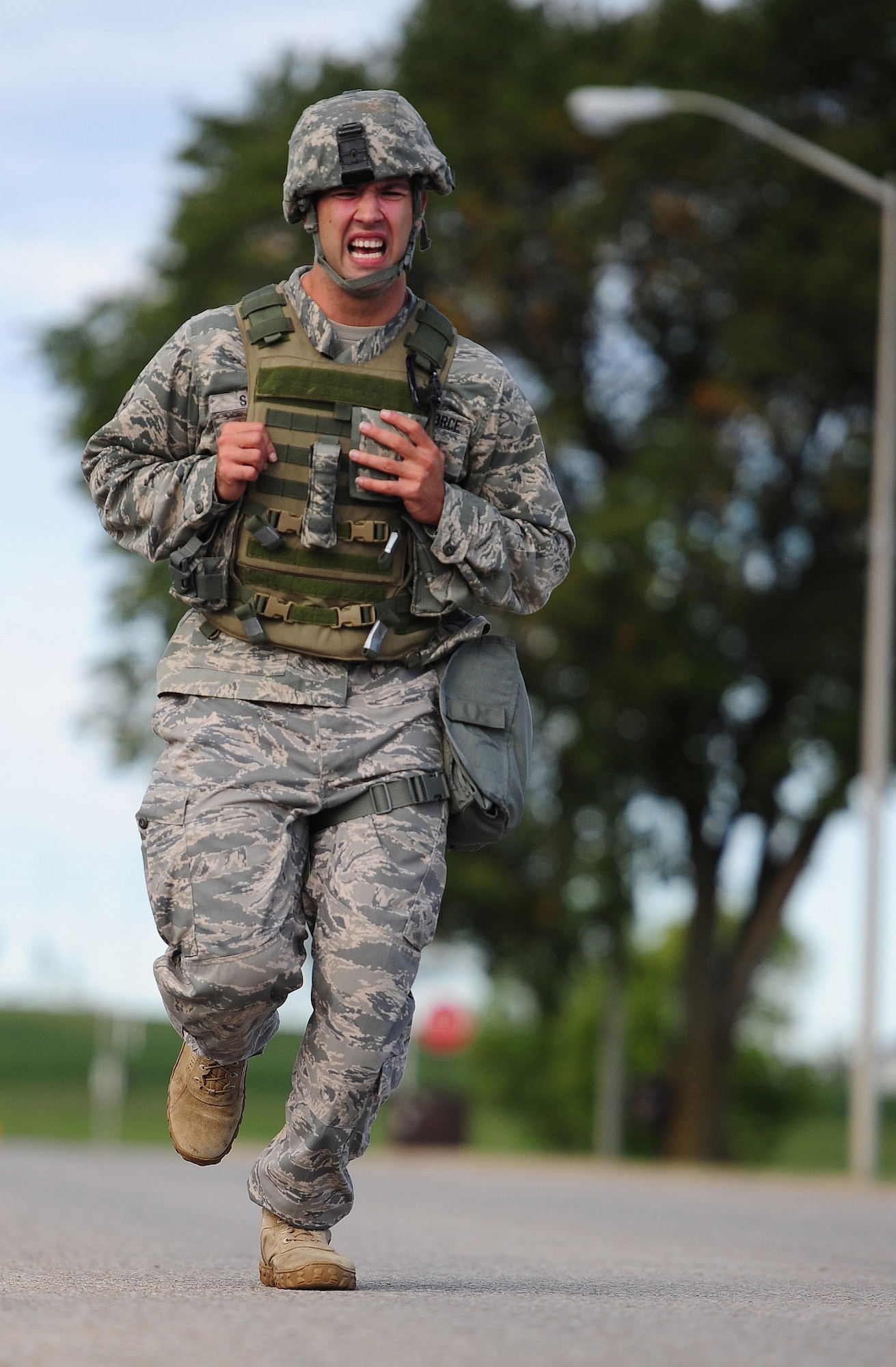 Senior Airman Angel Madrigal, 52nd Security Forces Squadron, completes the final lap of the running portion of the Air Force Global Strike Command Challenge try-outs here Sept. 21. Participants ran almost two miles with and without gas masks while wearing Kevlar helmets and vests. (U.S. Air Force photo/Senior Airman Nick Wilson) (RELEASED)