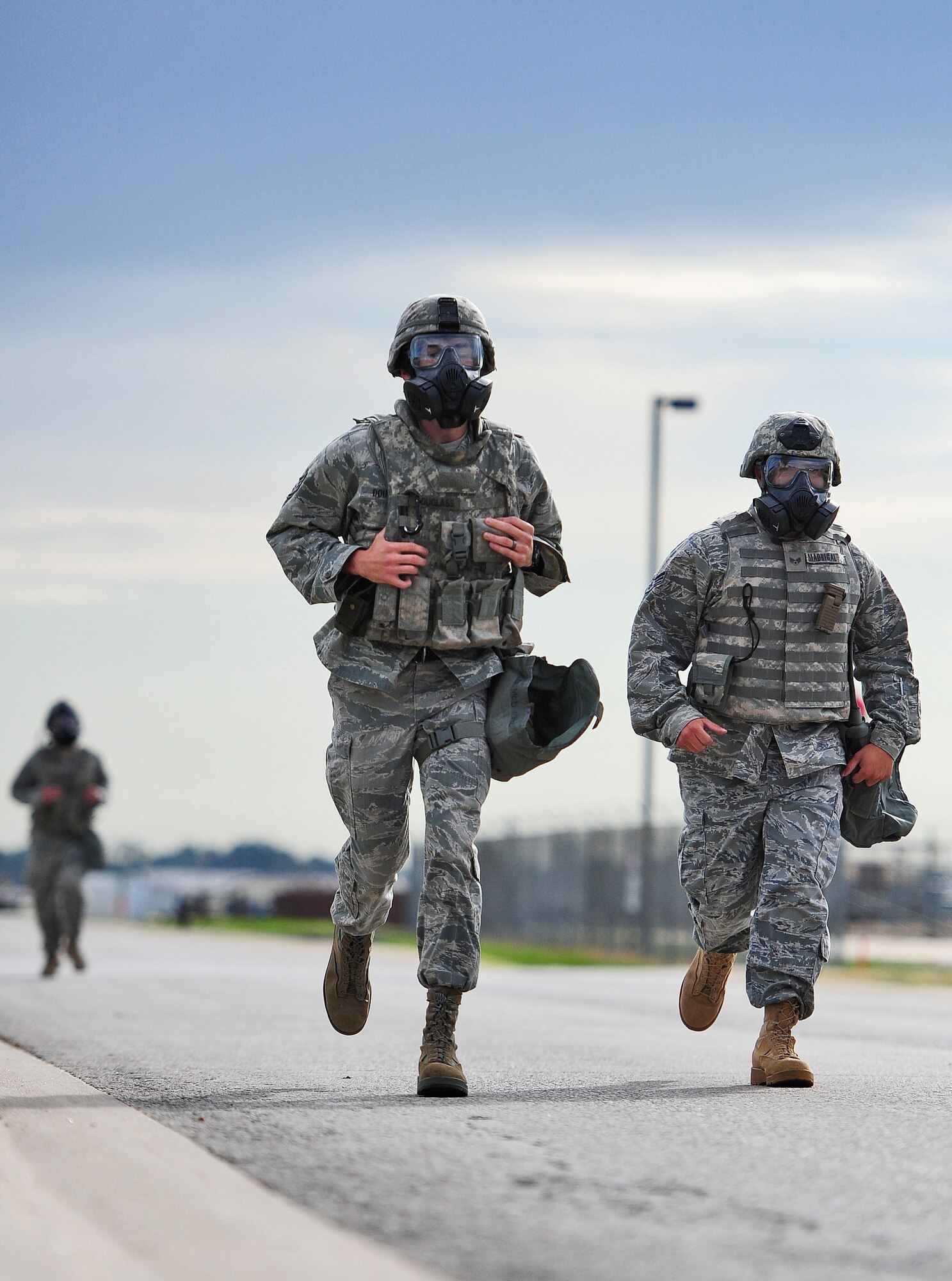 Airmen from the 509th Security Forces Squadron participate in the running portion of the Air Force Global Strike Command Challenge try-outs here Sept. 21. Participants ran almost two miles with and without gas masks while wearing Kevlar helmets and vests. (U.S. Air Force photo/Senior Airman Nick Wilson) (RELEASED)