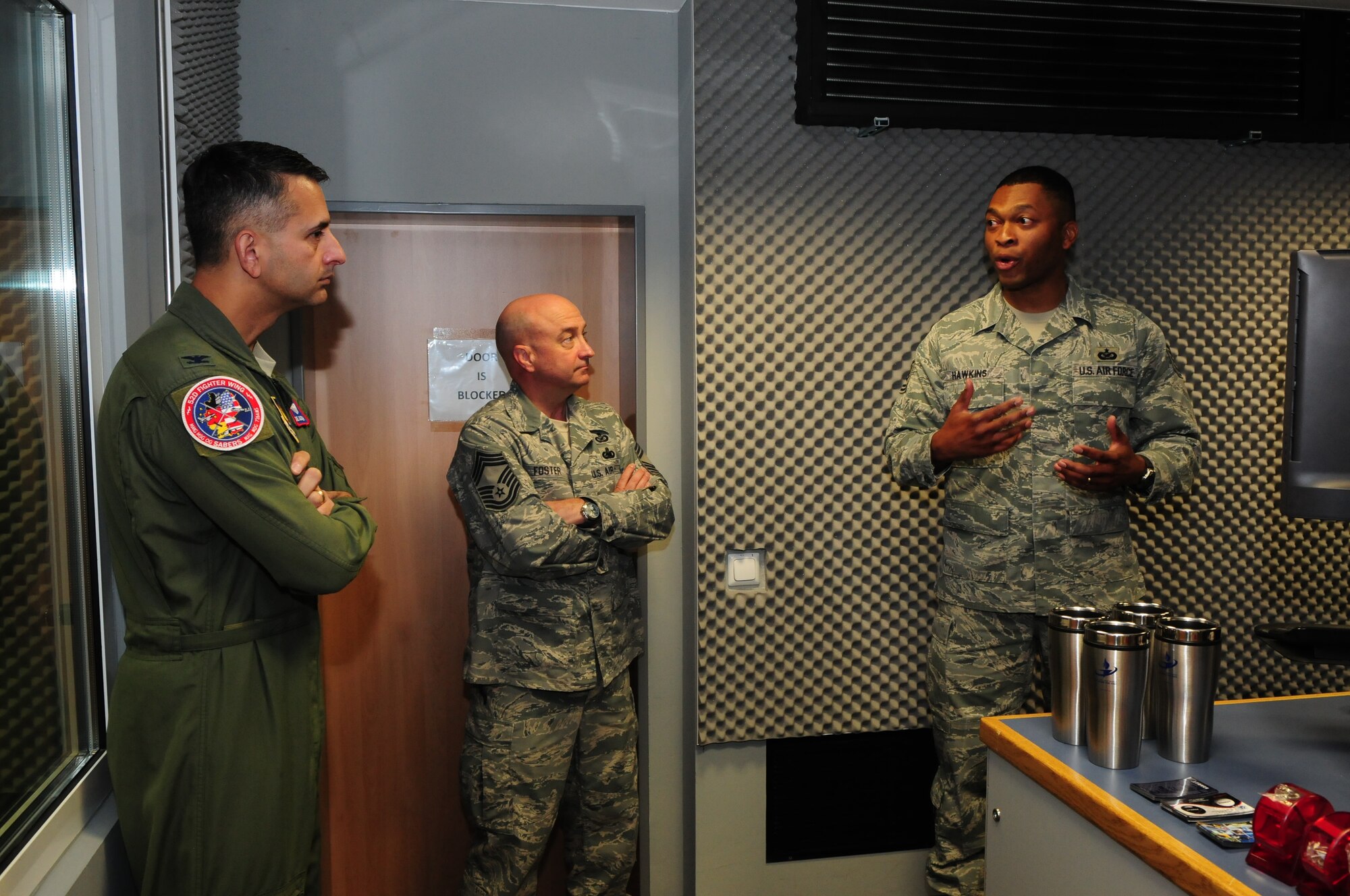 SPANGDAHLEM AIR BASE, Germany – Tech Sgt. Dwight Hawkins, American Forces Network Spangdahlem broadcast supervisor, talks with Col. David Julazadeh, 52nd Fighter Wing vice commander,  and Chief Master Sgt. Tyler Foster, AFN Europe operations chief, during a tour of the new AFN Spangdahlem facility after a ribbon-cutting ceremony here Sept. 30. Hawkins described the new capabilities the move from Bitburg Annex gives AFN Spangdahlem. (U.S. Air Force photo/Airman 1st Class Matthew B. Fredericks)