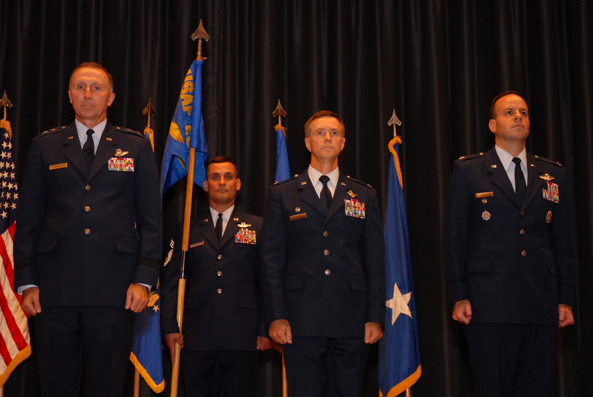 Maj. Gen. William Bender, U.S. Air Force Expeditionary Center commander, Col. Mark Ellis and Col. Patrick Owens, listen to the official orders naming Owens as the new commandant of the Expeditionary Operations School during the change-of-command ceremony Sept. 26 at Joint Base McGuire-Dix-Lakehurst. (U.S. Air Force photo by Tech. Sgt. Paul Evans/Released)