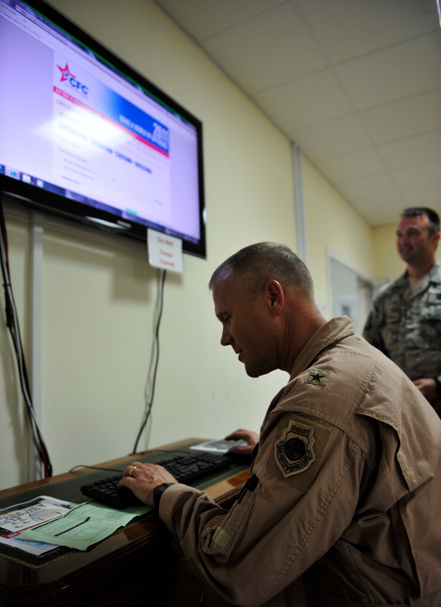 Brig. Gen. Jeffrey Lofgren, the 380th Air Expeditionary Wing commander, makes the first donation, Oct. 3, 2011, to kick off the annual Combined Federal Campaign-Overseas drive at the 380th AEW. This is the 50th anniversary of the CFC-O, which will be held Oct. 3 through Dec. 2 at the deployed wing in Southwest Asia.  (U.S. Air Force photo/Tech. Sgt. Patrick Mitchell)
