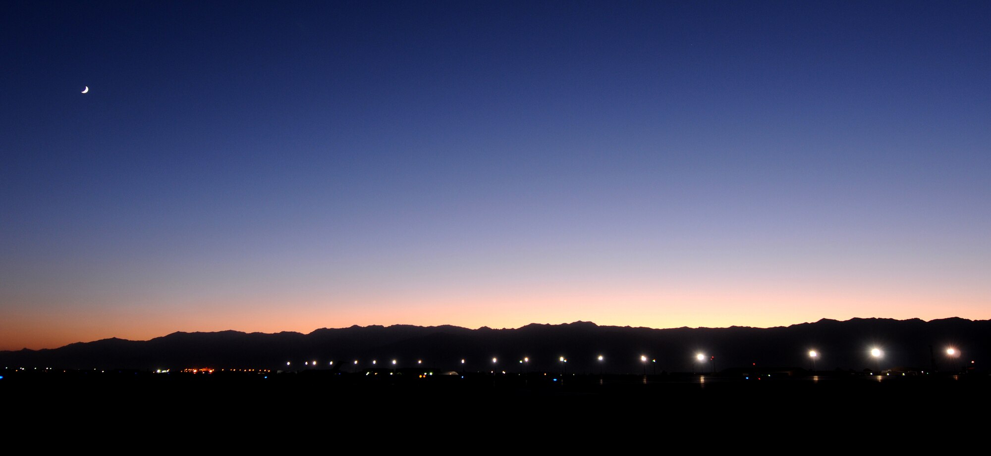 BAGRAM AIRFIELD, Afghanistan -- The moon rises over Bagram Airfield Oct. 01,
2011. Bagram is home to the 455th Air Expeditionary Wing, which is comprised
of more than 3000 Airmen. The wing serves U.S. Air Forces Central by
providing air mobility, close air support, combat search rescue, aerial
intelligence, surveillance and reconnaissance, electronic attack and command
and control assets which support the International Security Assistance Force
and Operation Enduring Freedom. (U.S. Air Force photo/Senior Airman
Krista Rose)
