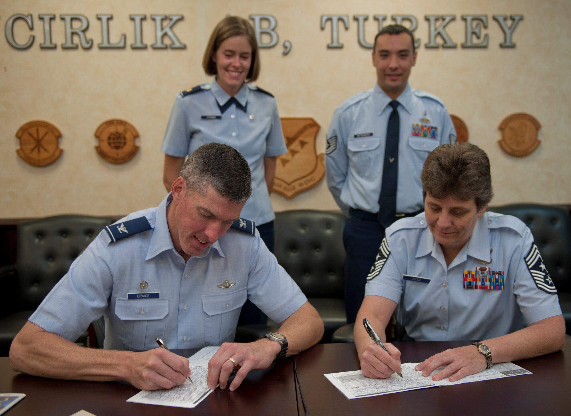Col. Chris Craige, 39th Air Base Wing commander, bottom left, and Chief Master Sgt. Nancy Judge, 39th ABW command chief, bottom right, sign their donation lists for the 2011 Combined Federal Campaign Overseas Oct. 3, 2011, at Incirlik Air Base, Turkey. The CFC-O is the only Department of Defense authorized solicitation of federal employees in their workplaces on behalf of approved charitable organizations. Incirlik's goal for this year is $80,000 in donations. The campaign ends Dec. 2, 2011. (U.S. Air Force photo by Senior Airman Anthony Sanchelli/Released)